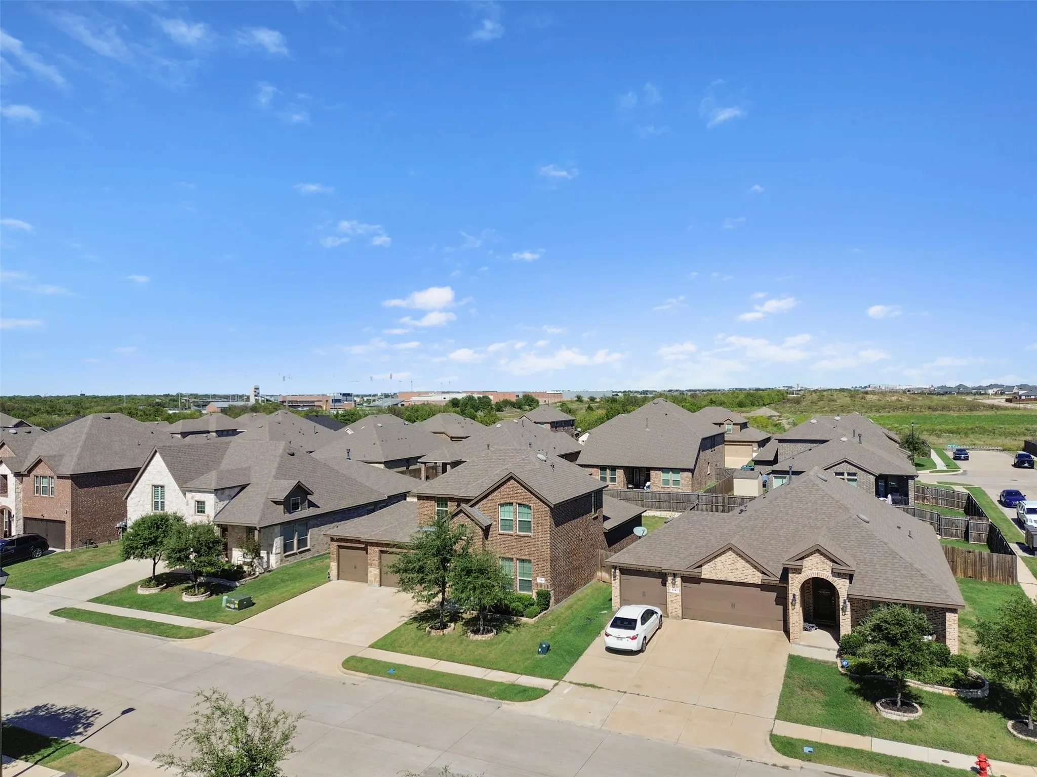 Brick exterior, gabled roofline, attached two-car garage, concrete driveway, and landscaped front yard