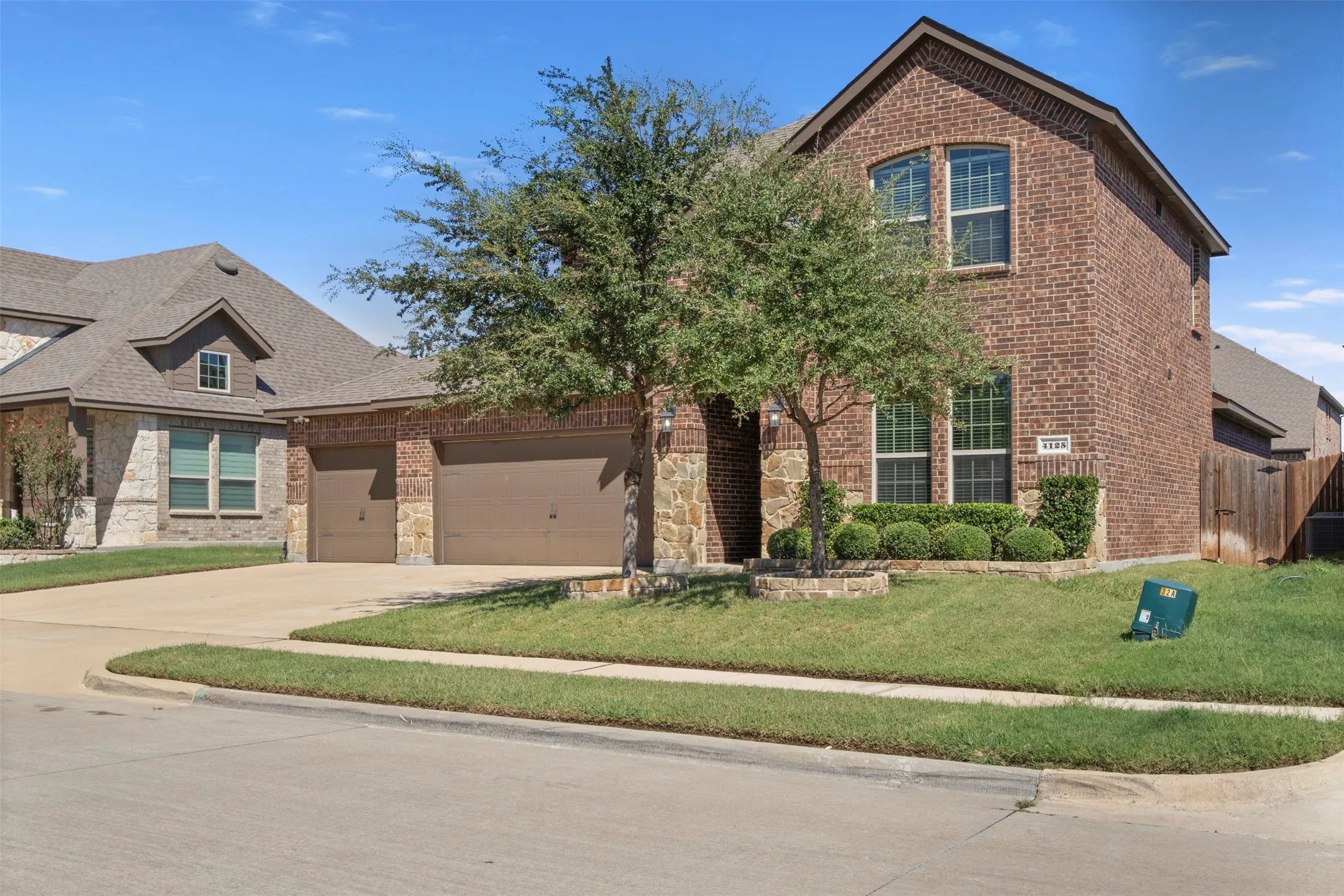 Brick and stone facade with arched windows, gabled roofline, and an attached two-car garage
