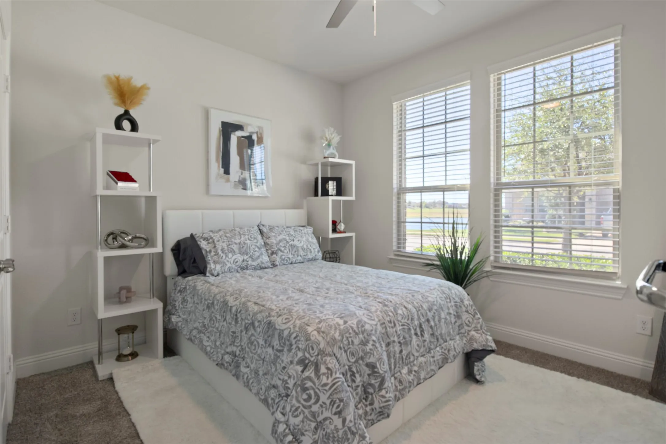 Dual windows with blinds, neutral wall paint, and carpeted flooring