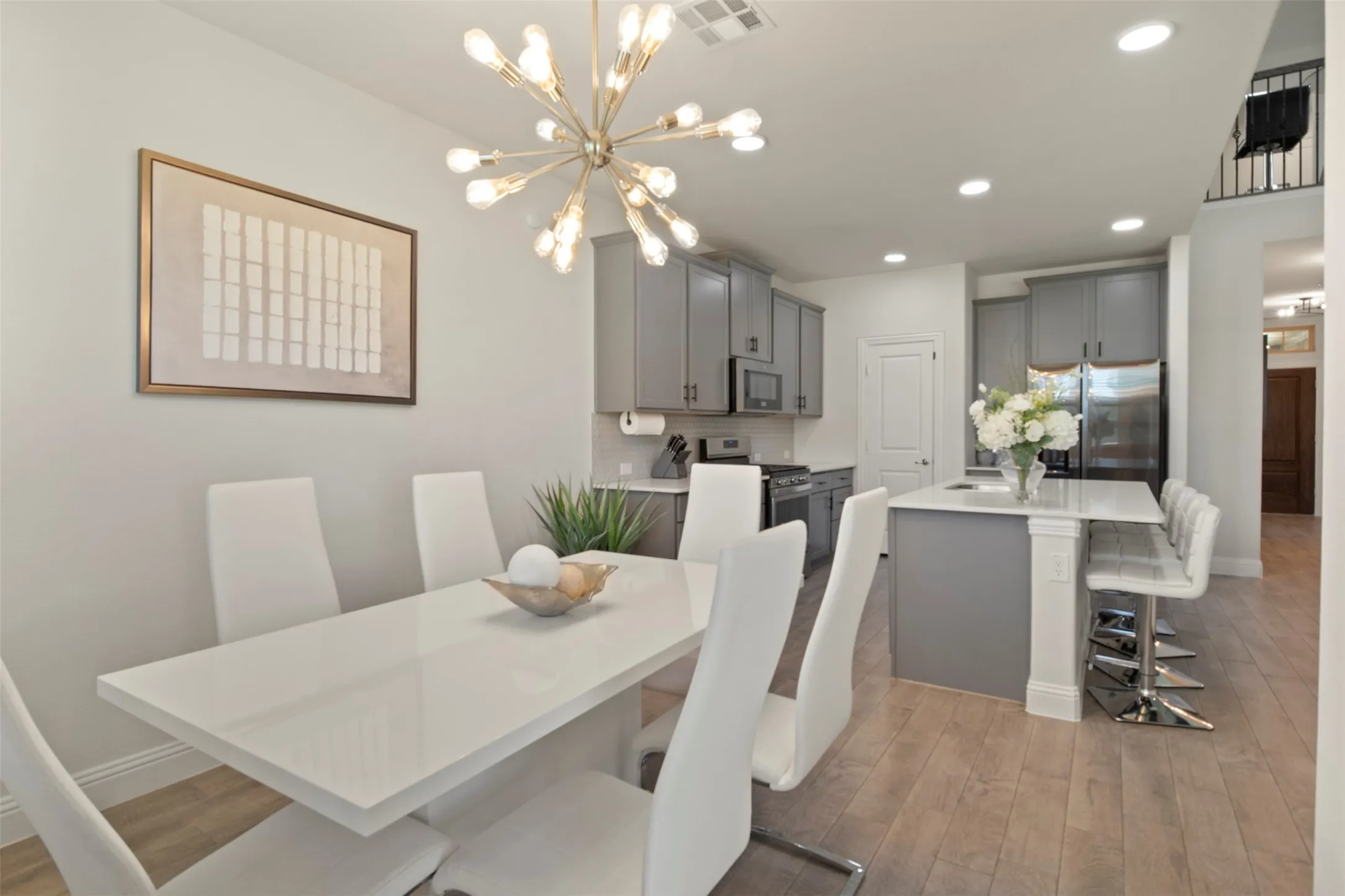 Open-concept living area with wood-finish flooring, recessed lighting, and a modern chandelier