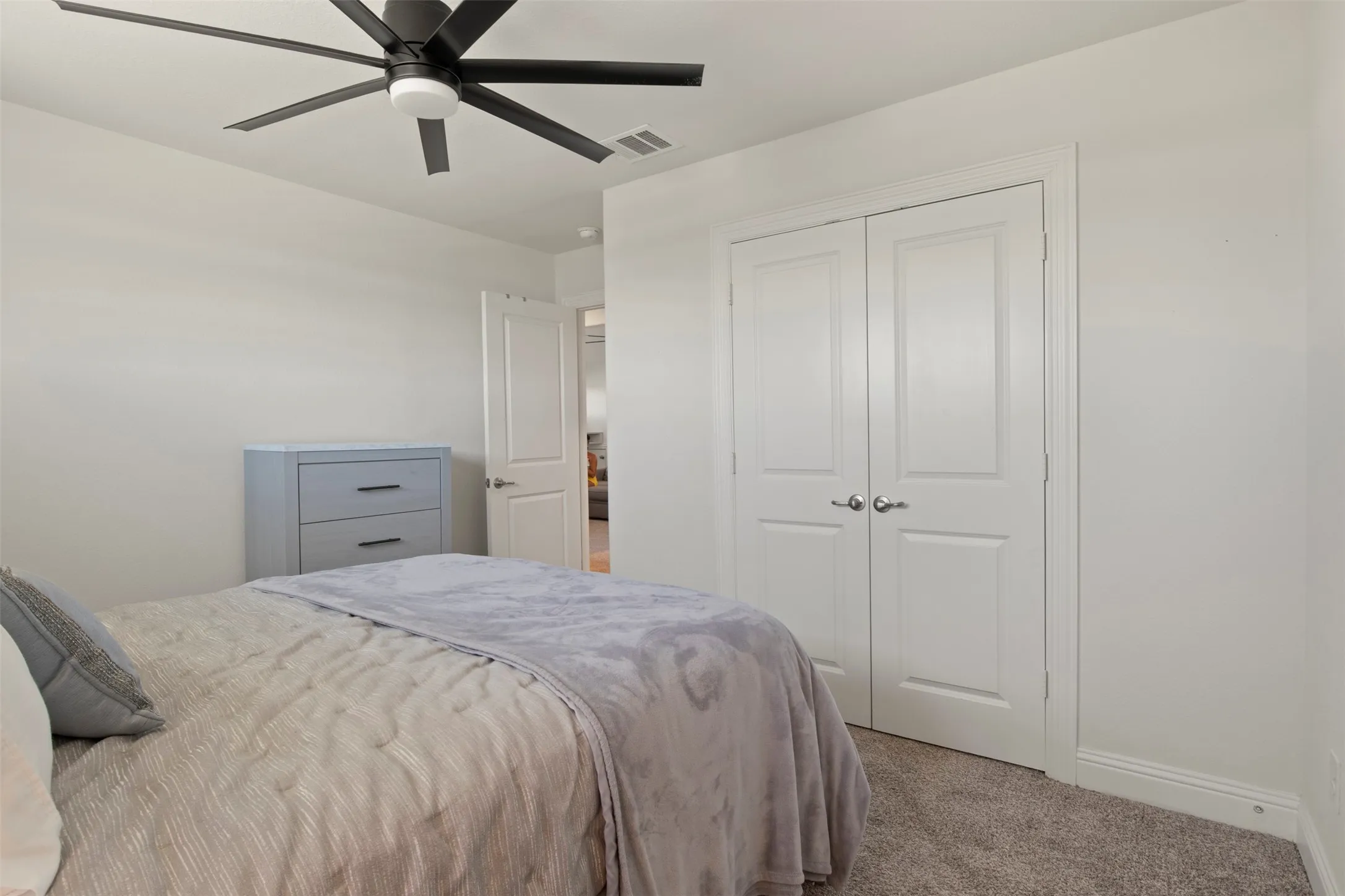 Ceiling fan with integrated lighting, white interior doors, and neutral wall tones