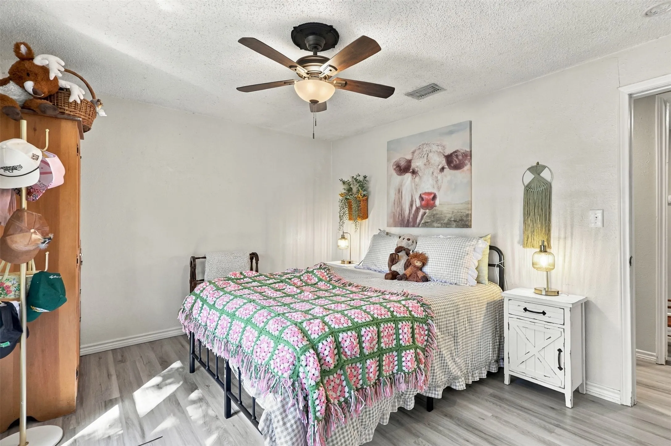 Wood-finish flooring, ceiling fan, white baseboards, and light-colored walls