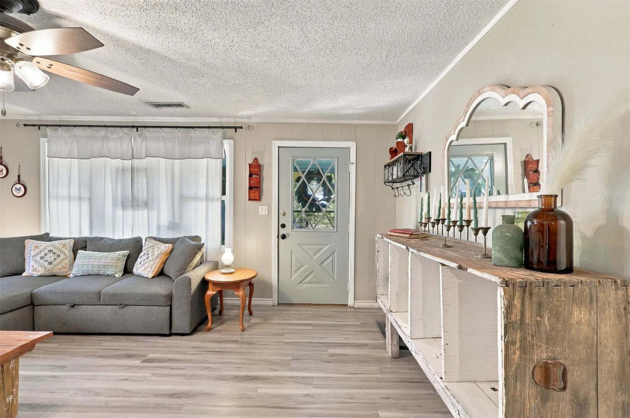 Light wood-finish flooring, recessed lighting, and a detailed front entry door