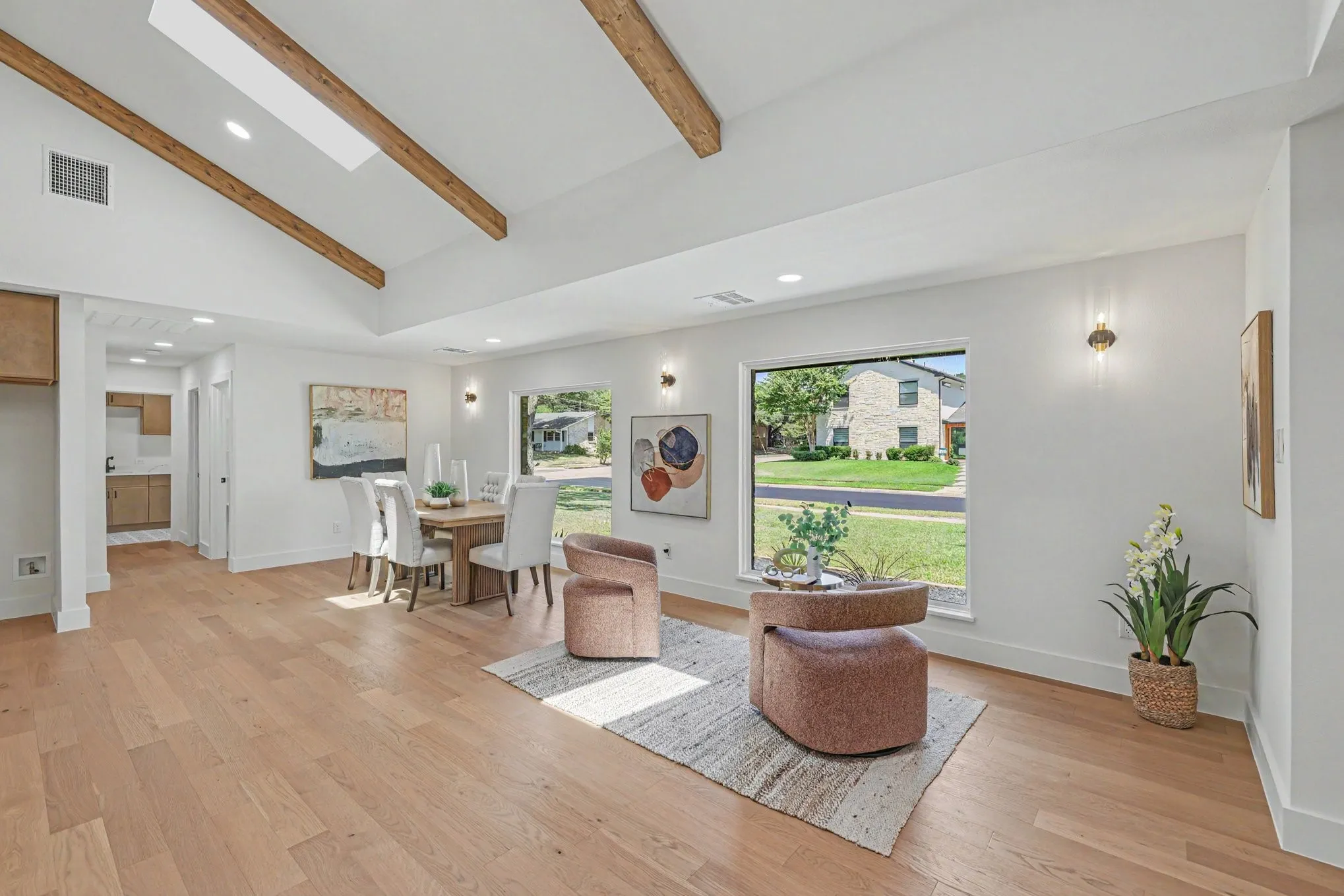 Vaulted ceiling with exposed wood beams, skylight, wood-finish flooring, and recessed lighting