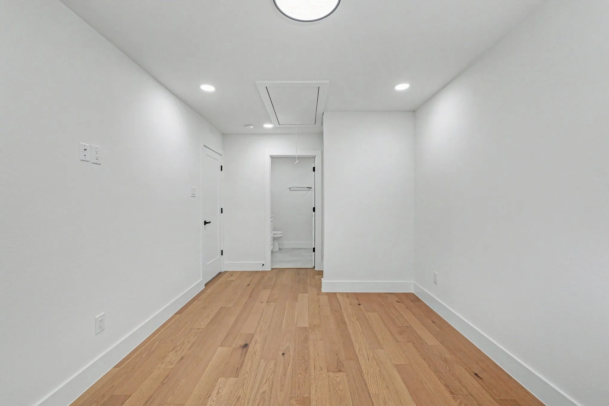 Recessed lighting, wood-finish flooring, white walls, and a white ceiling with a flush-mount light fixture