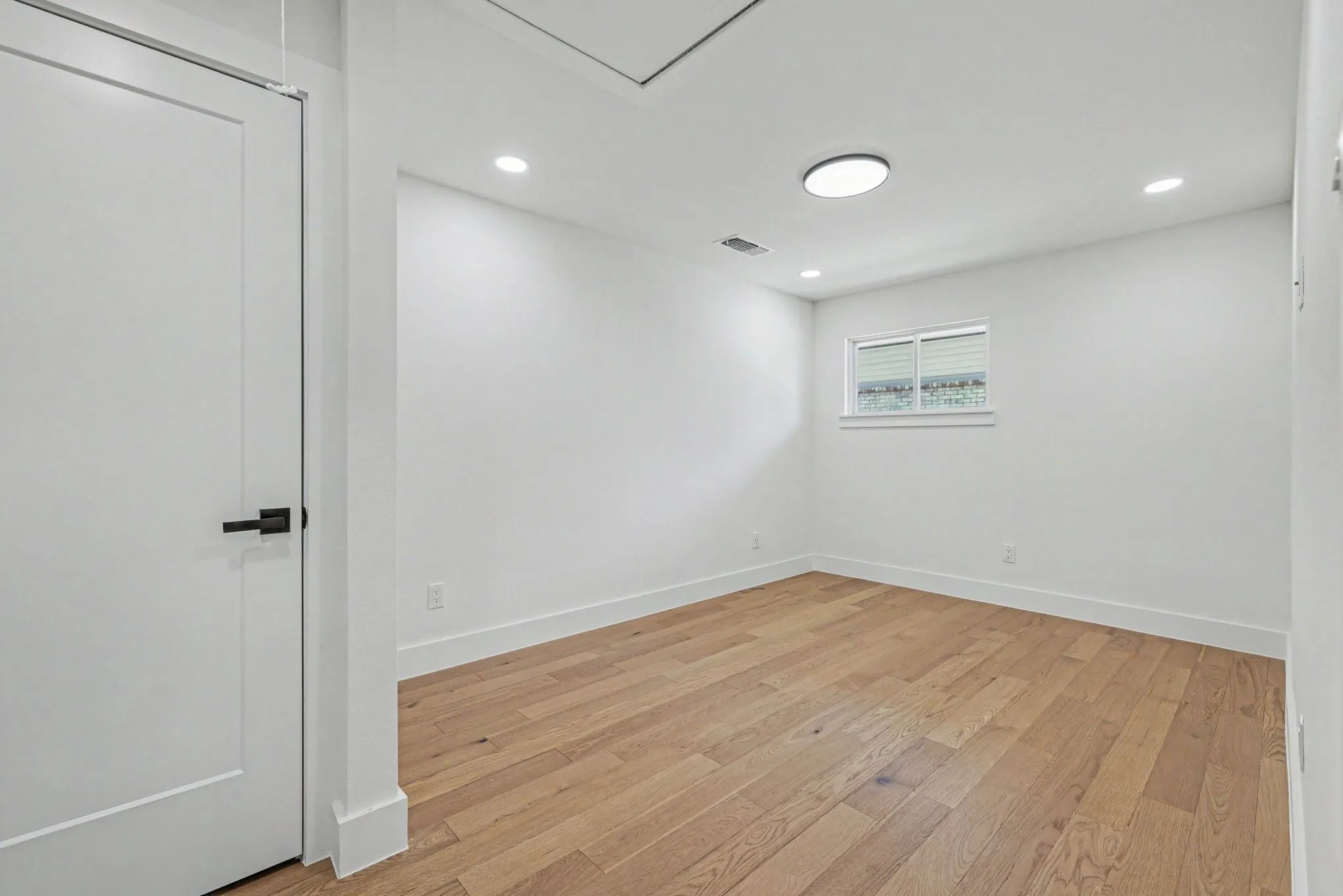 Wood-finish flooring, recessed lighting, and a window with blinds