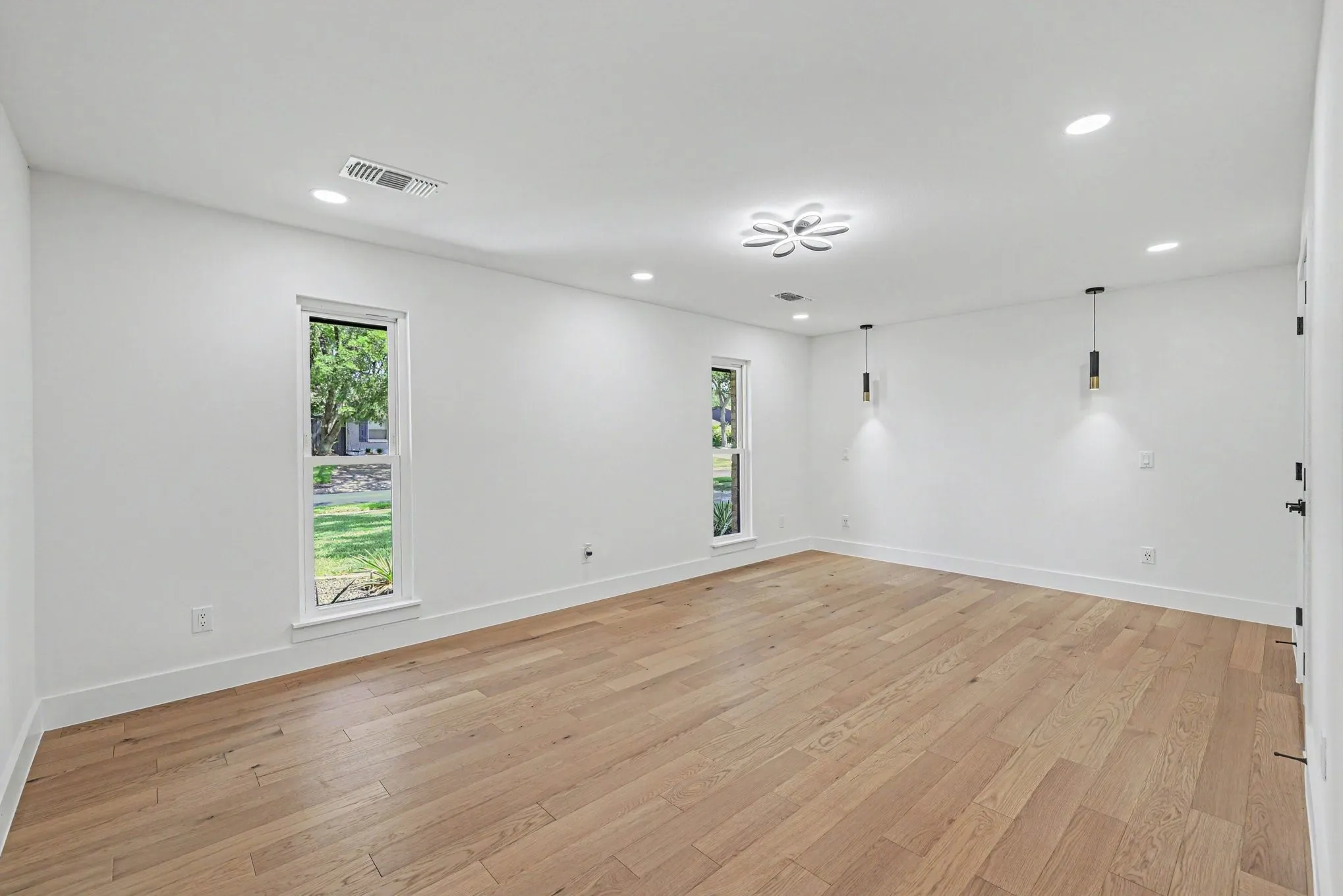 Recessed lighting, wood-finish flooring, and white walls