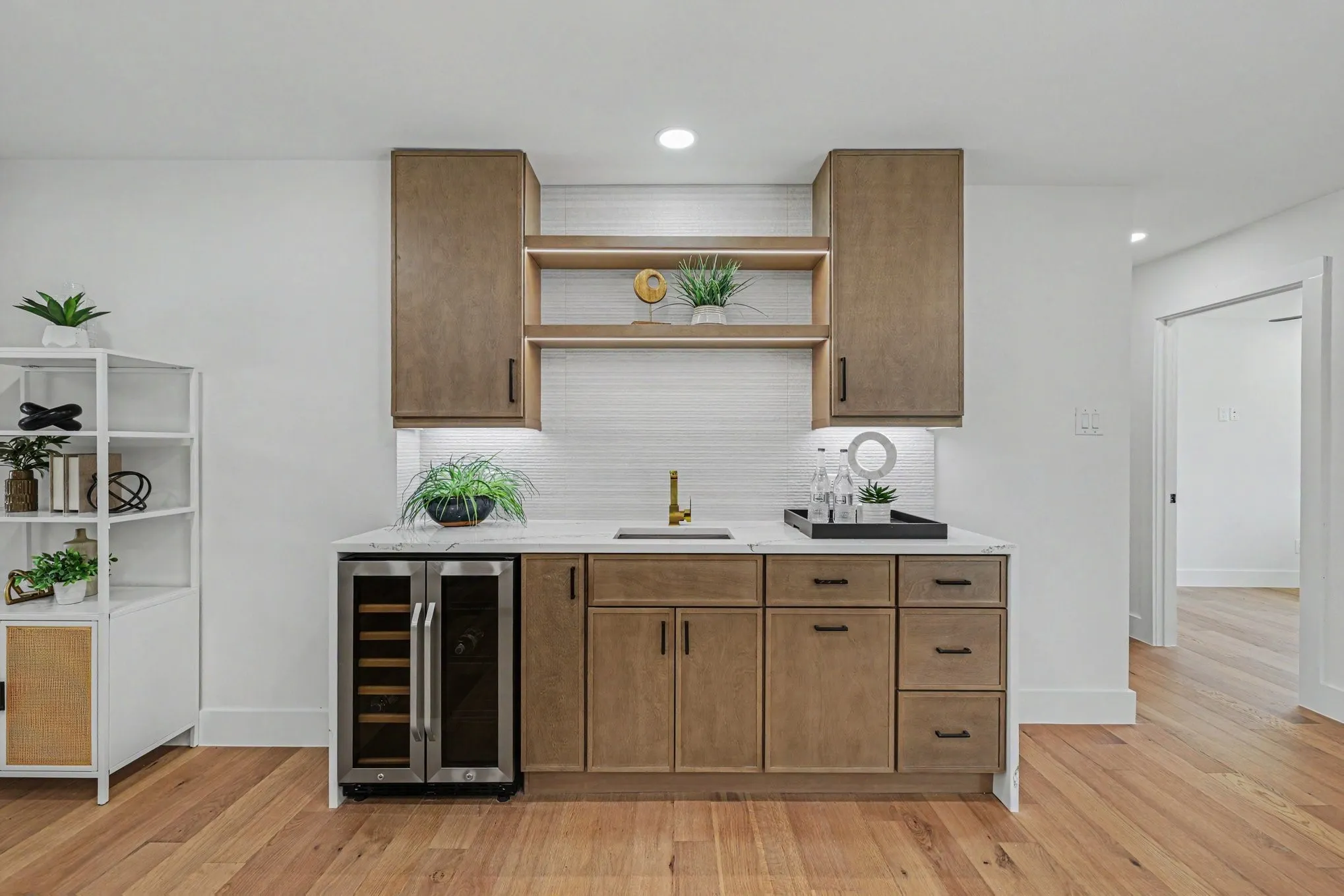 Built-in wet bar with wood-finish cabinetry, under-cabinet lighting, and a beverage refrigerator