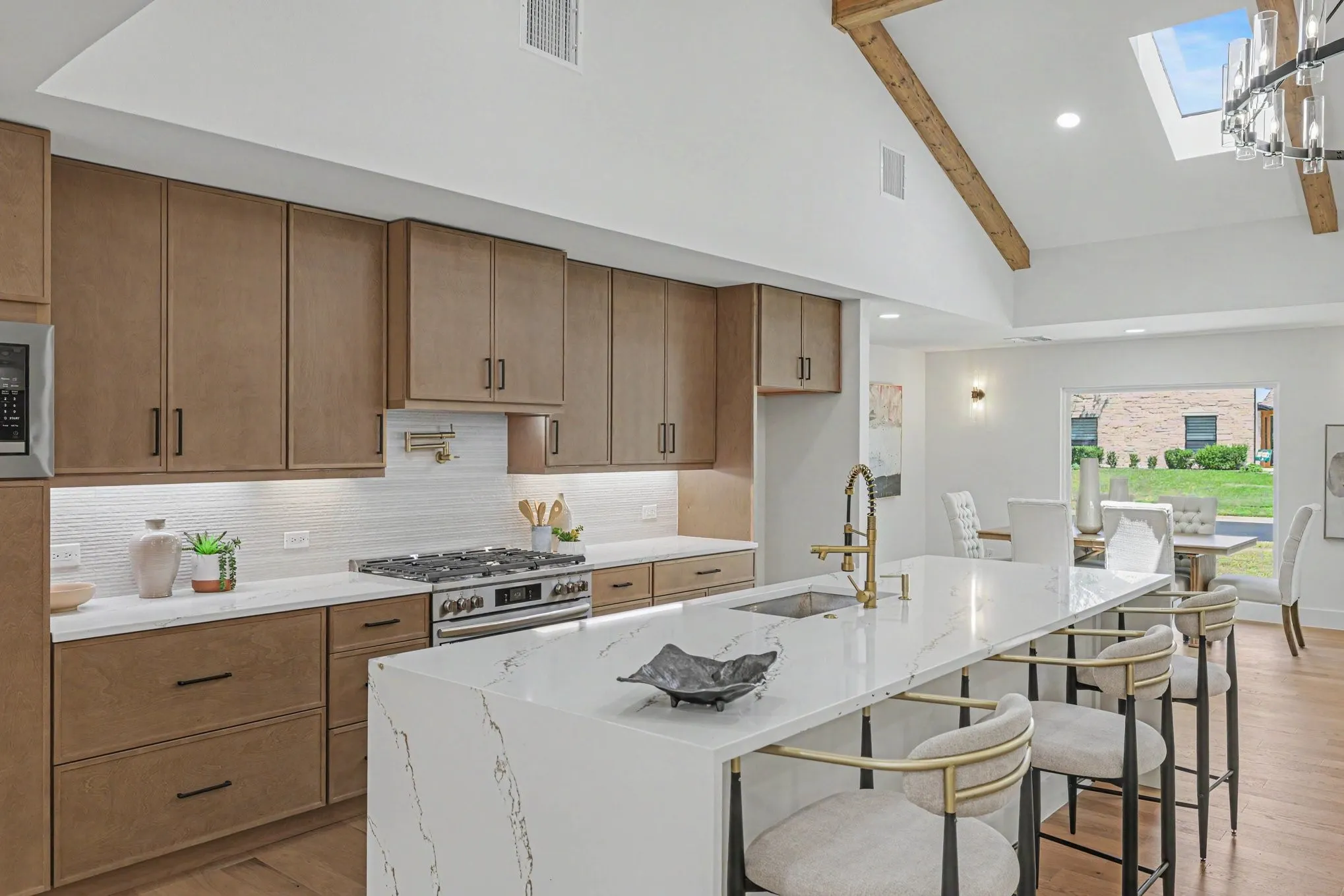 Vaulted ceiling with exposed wood beams, skylight, and recessed lighting