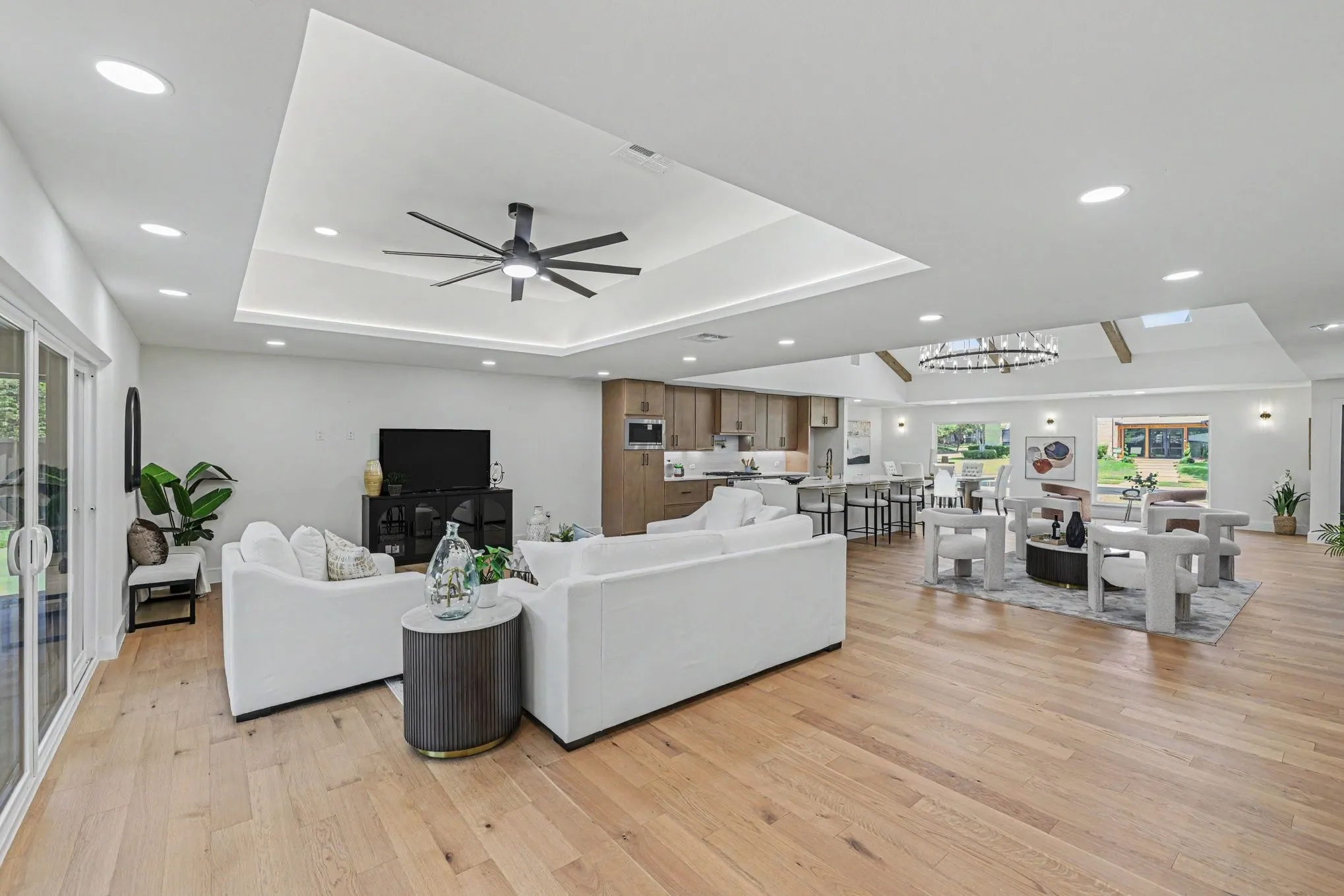 Recessed lighting, wood-finish flooring, sliding glass doors, contemporary ceiling fan, and open-concept design
