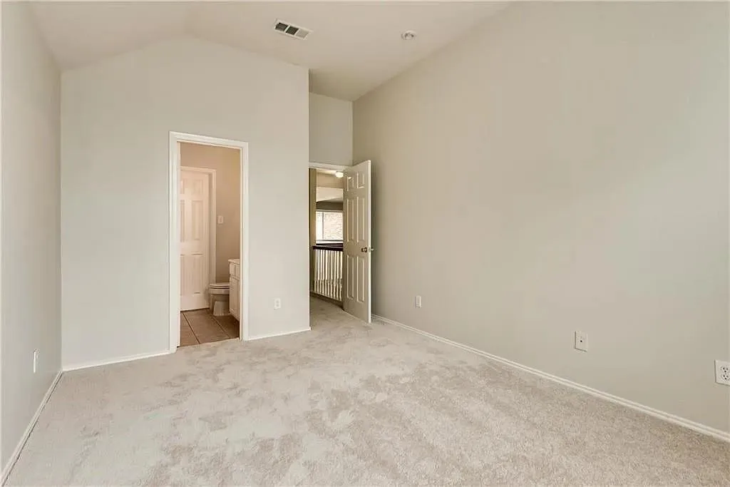 Vaulted ceiling, neutral wall tones, carpeted flooring, recessed lighting, and a white six-panel door