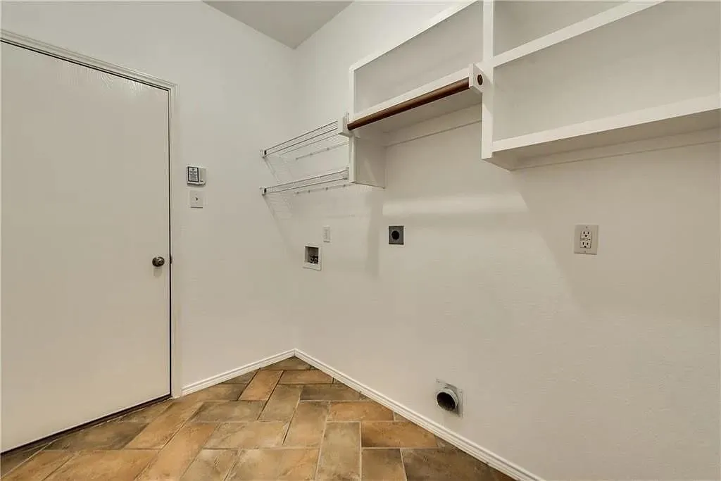 Built-in shelving, hanging rod, wall-mounted drying rack, utility hookups, and a privacy door