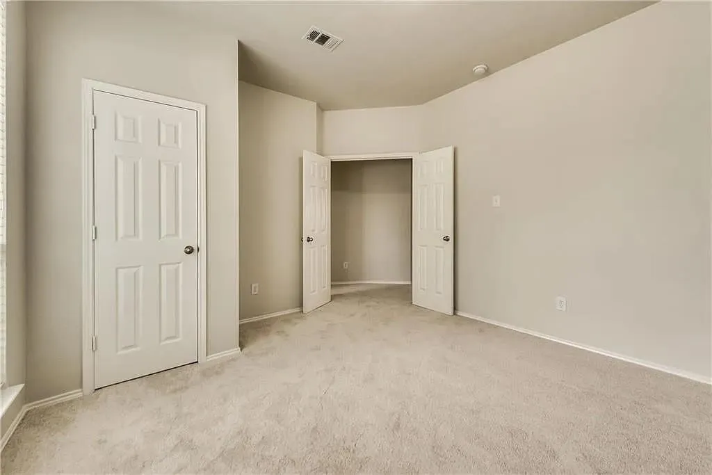 Neutral wall paint, plush carpet flooring, paneled interior doors, and a built-in closet space