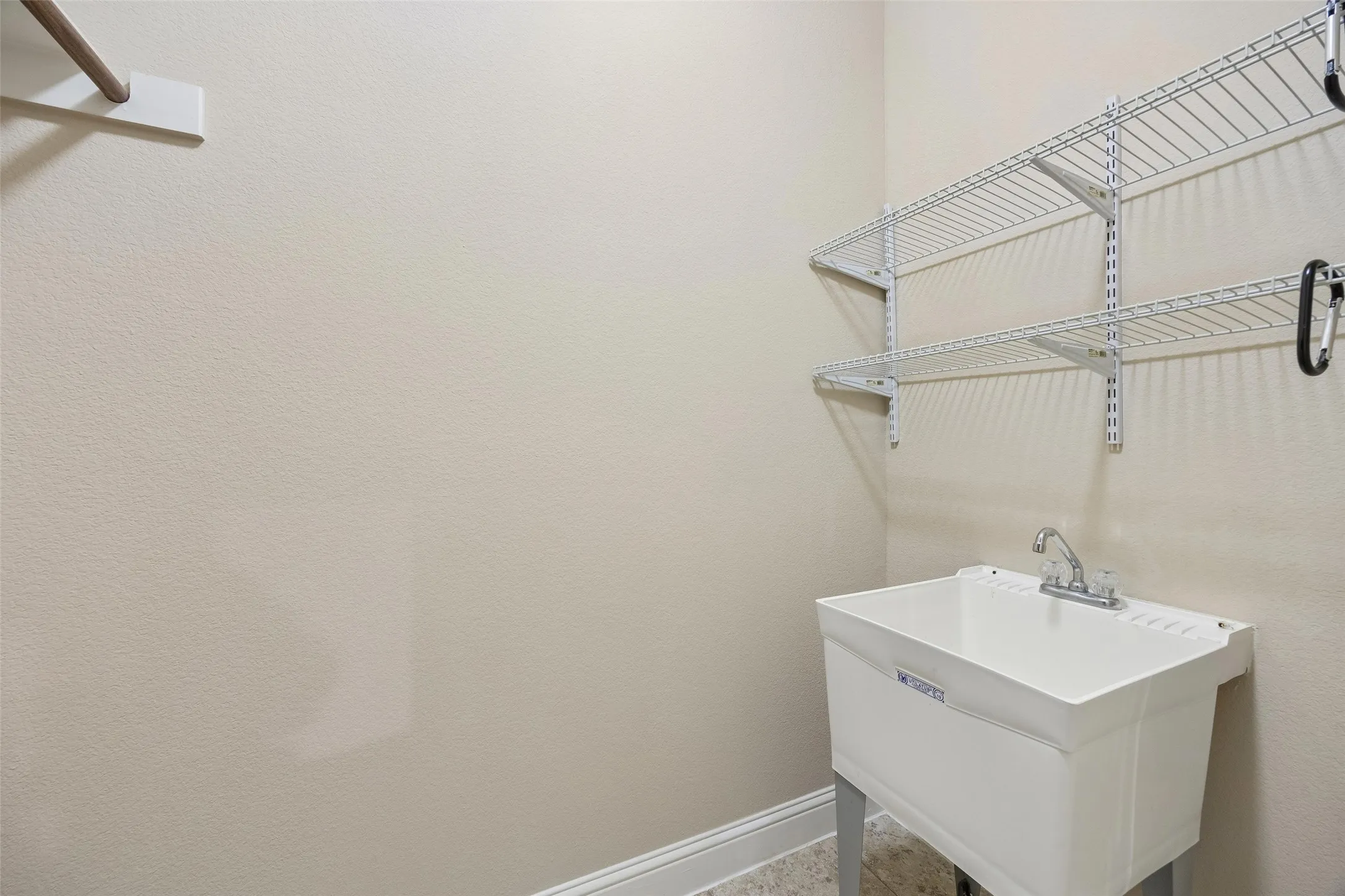 Utility sink in Laundry room. *Opposite wall has the space for full washer and dryer and a built in cabinet.