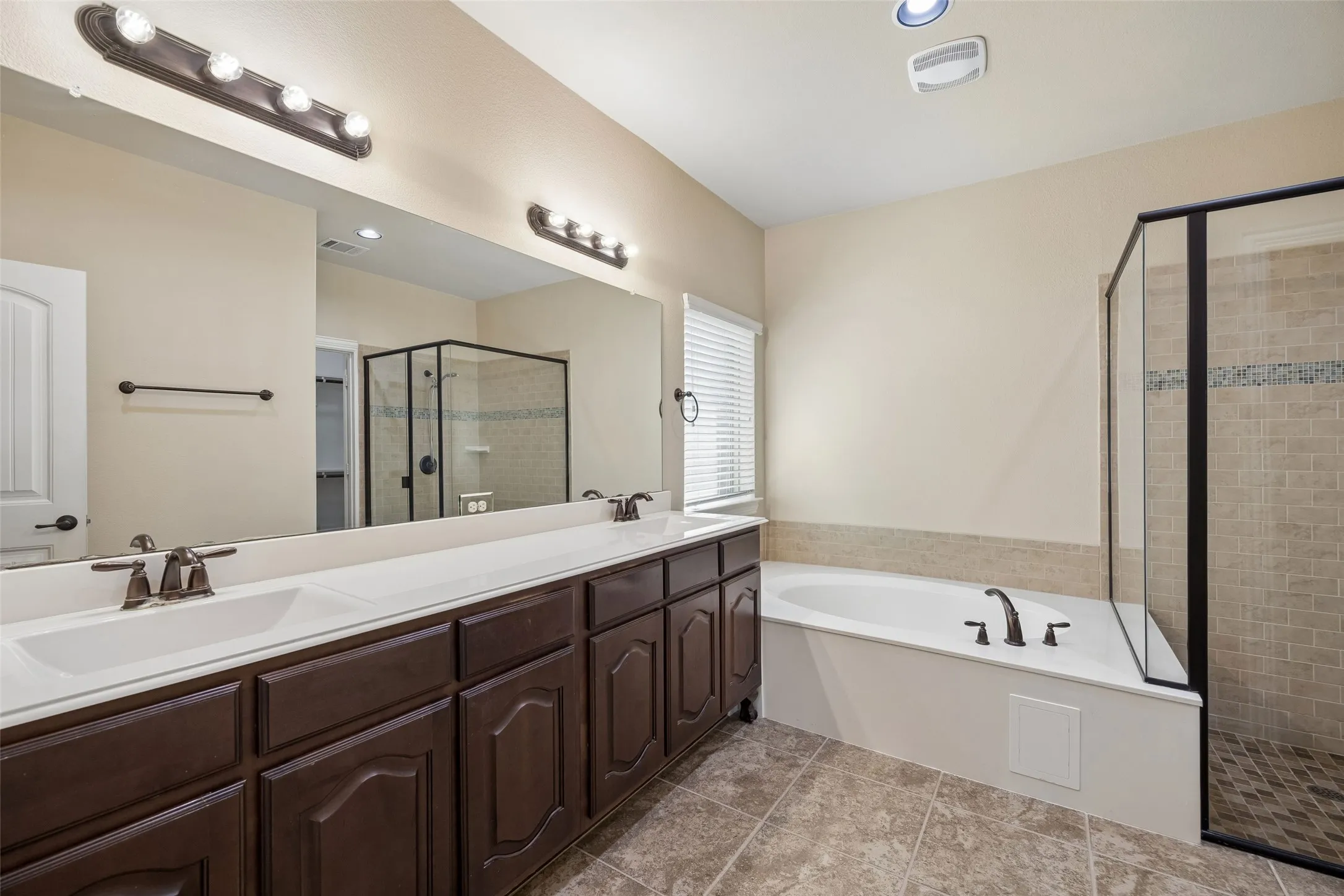 Dual vanity with integrated sinks and dark wood-finish cabinetry