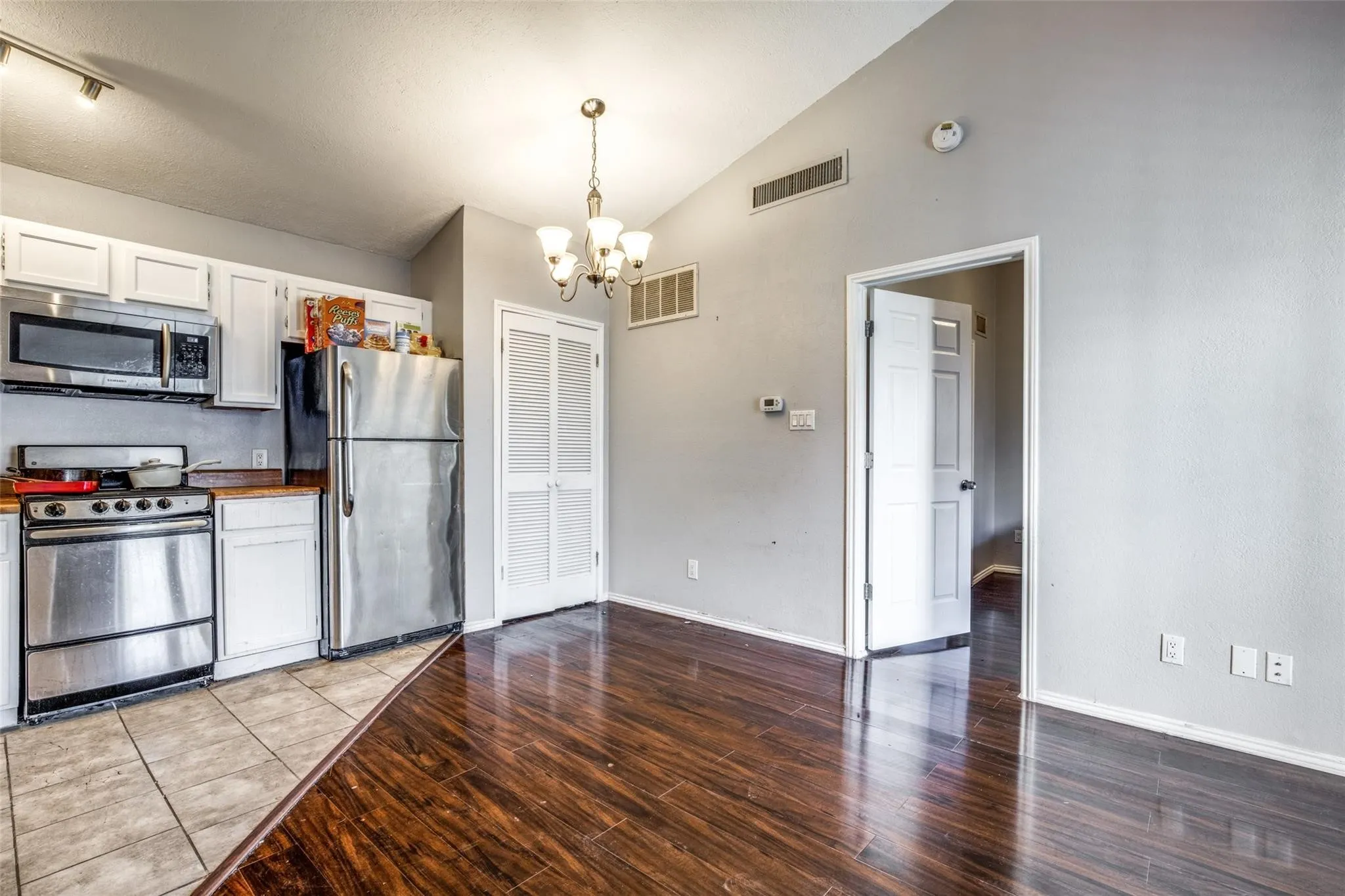 Kitchen with stainless steel appliances, white cabinetry, and wood-finish countertops