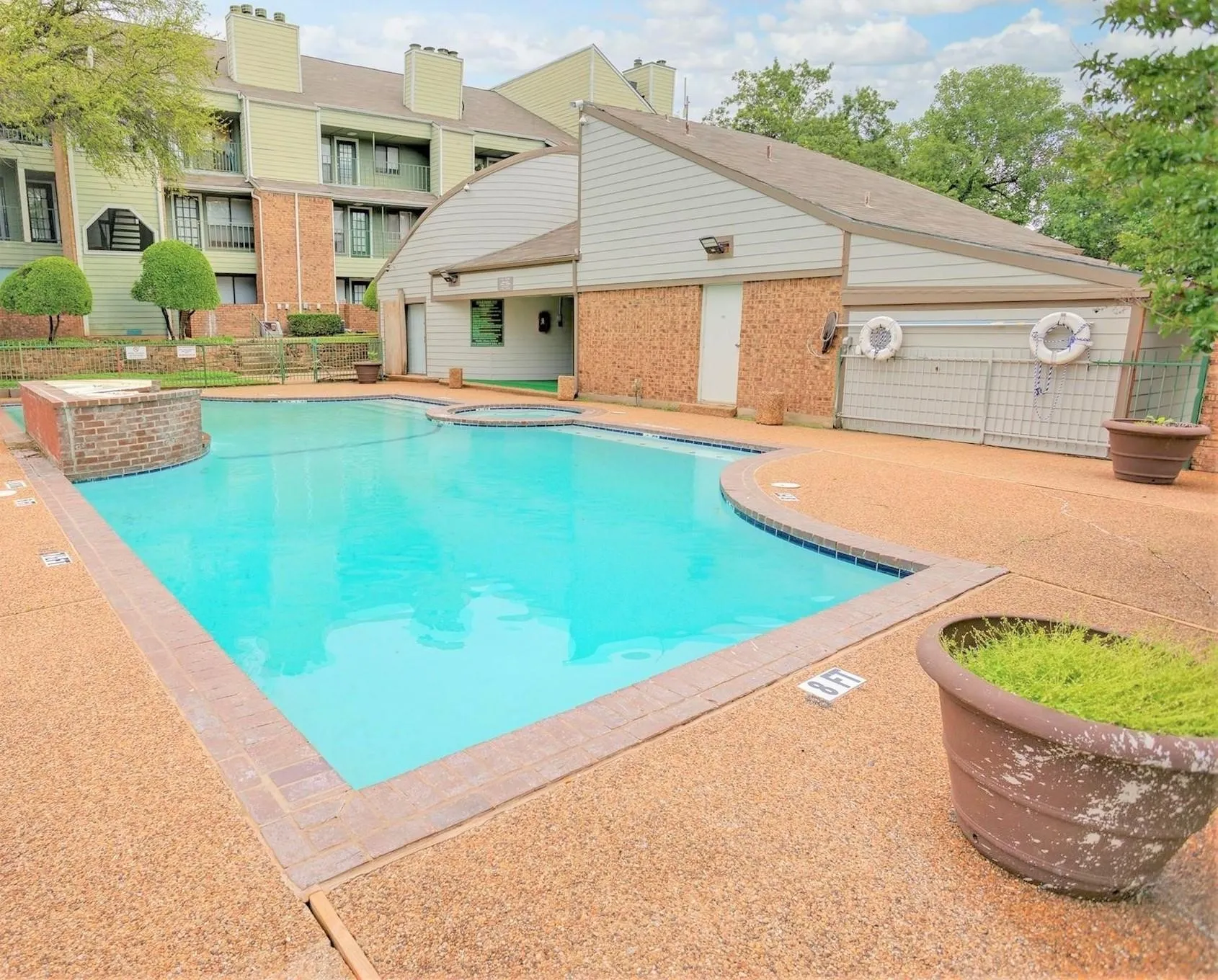 Swimming pool with integrated spa and surrounding exposed aggregate concrete decking
