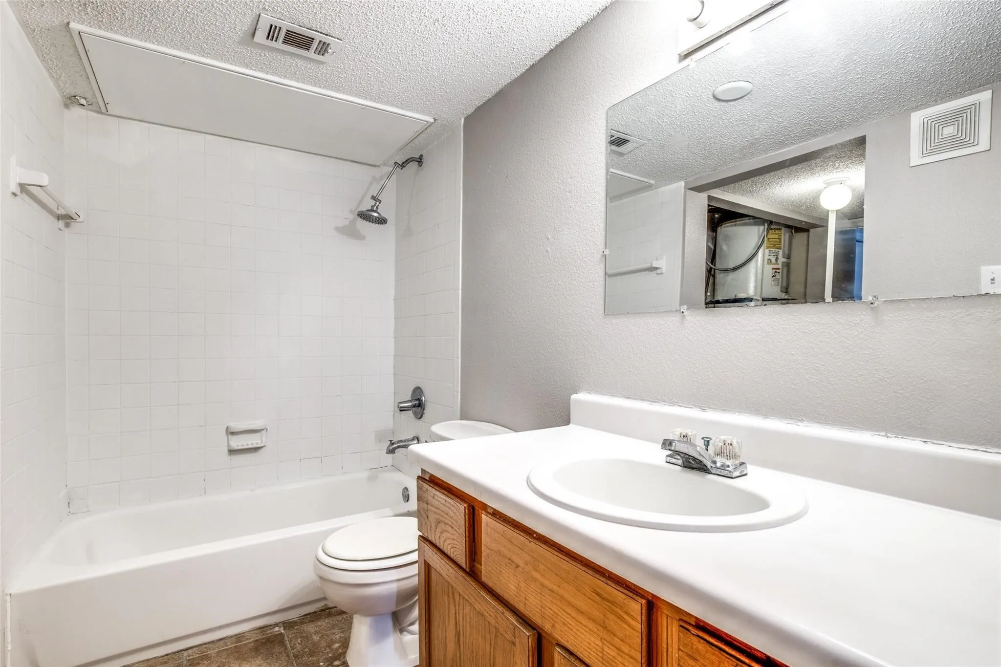 White tiled shower/tub combination with a chrome showerhead