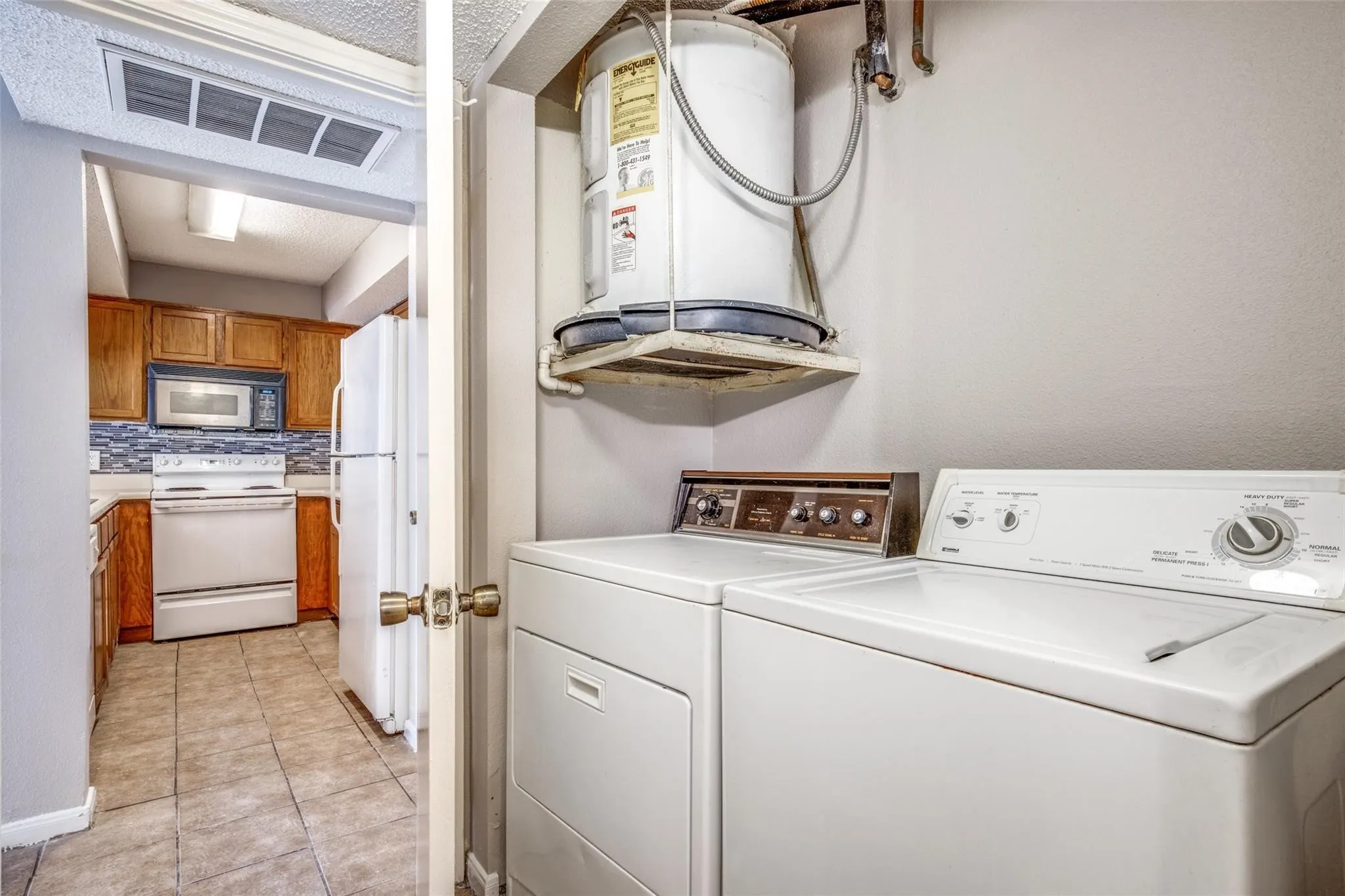 Kitchen featuring wood-finish cabinetry, tile flooring, and a patterned backsplash