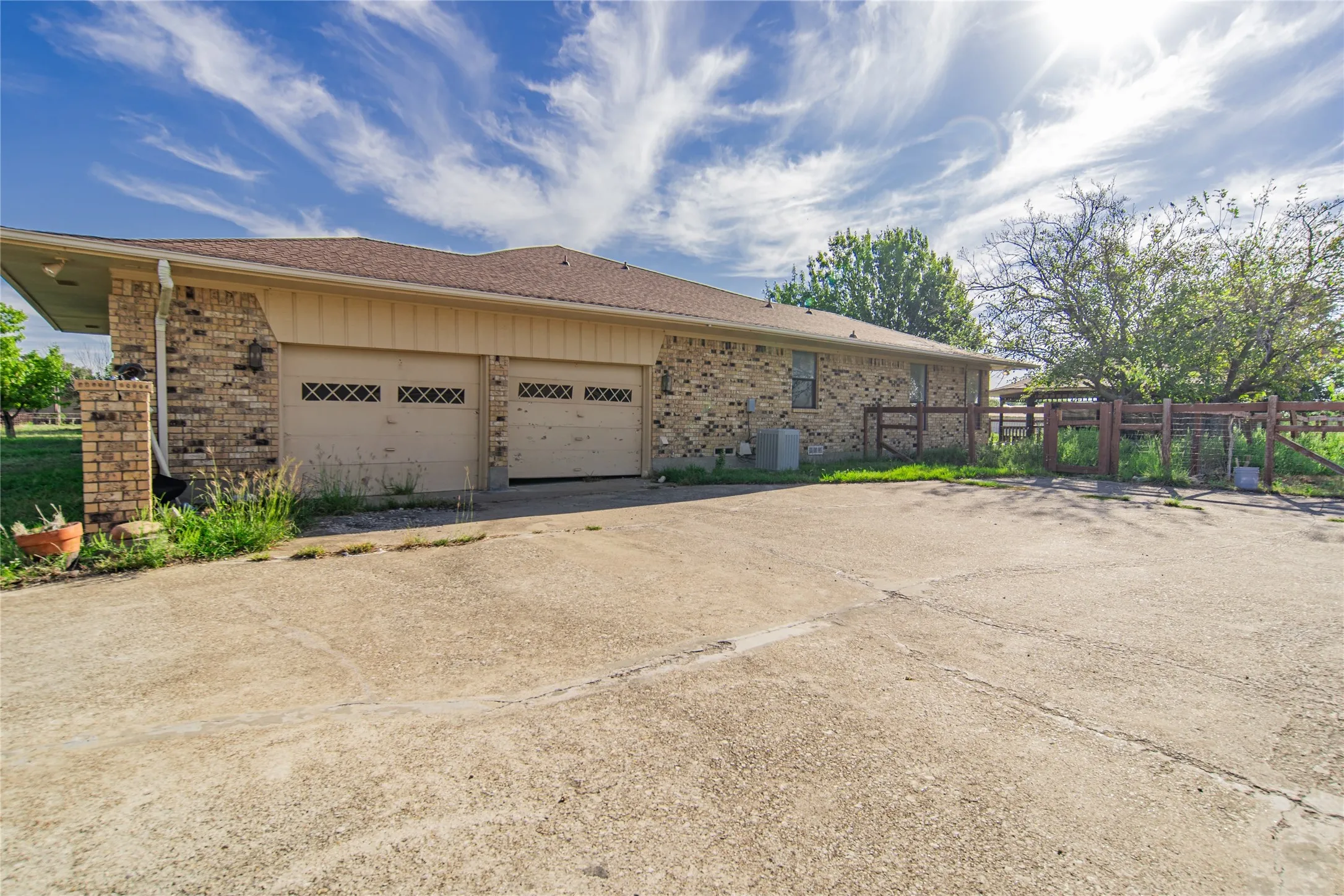 Brick exterior with a shingle roof and a two-car garage