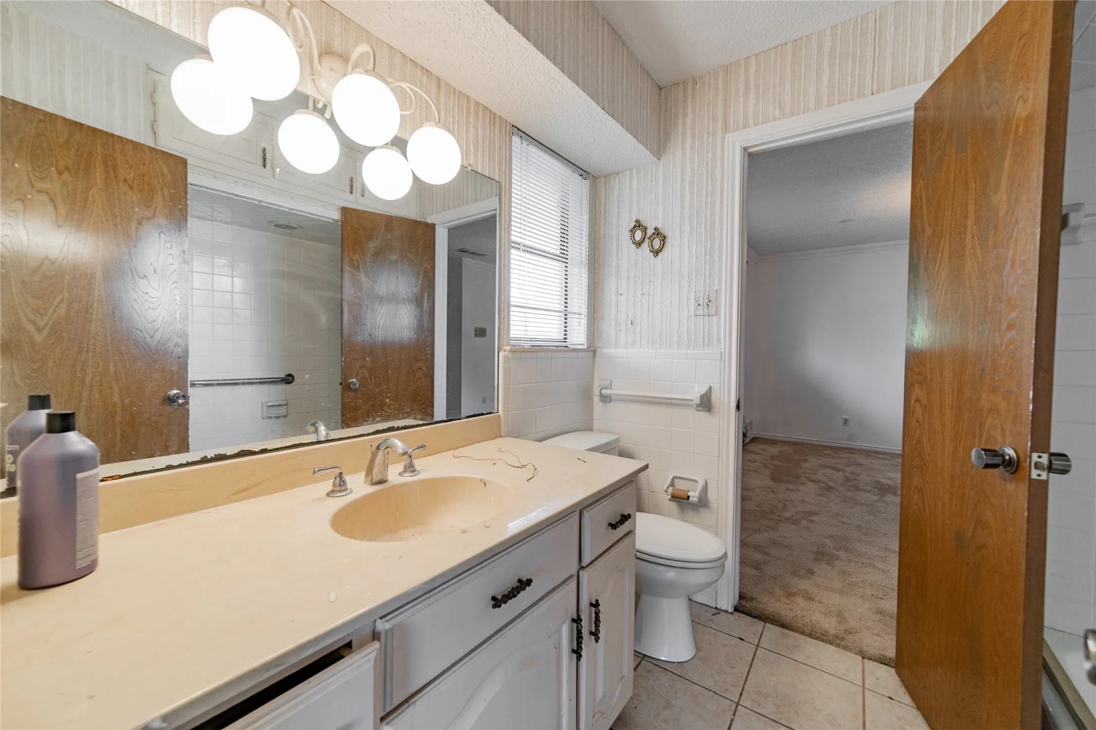 Vanity with integrated sink, chrome faucet, and white cabinetry