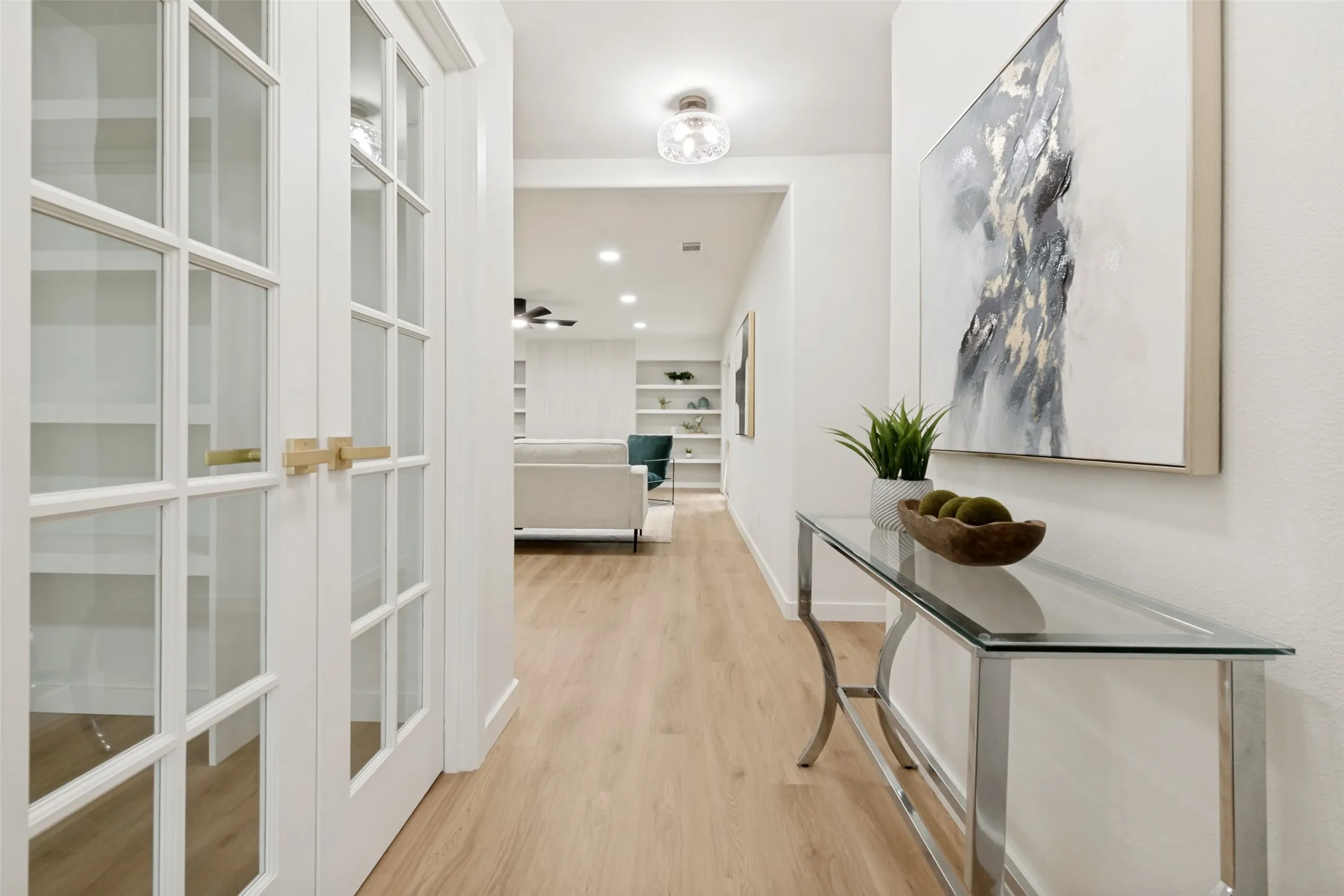 View from front door to double office doors and living room fireplace