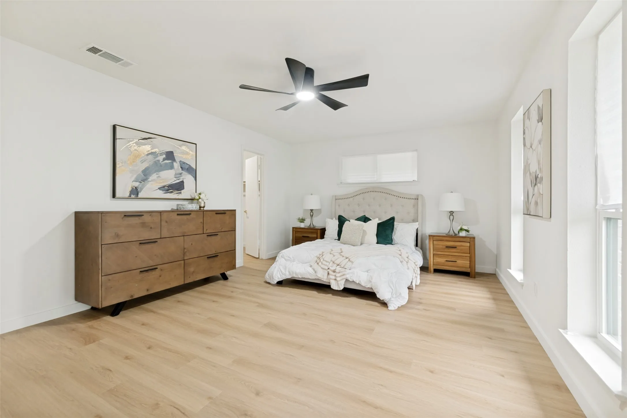 Large primary bedroom with walk in closet and natural light from front windows