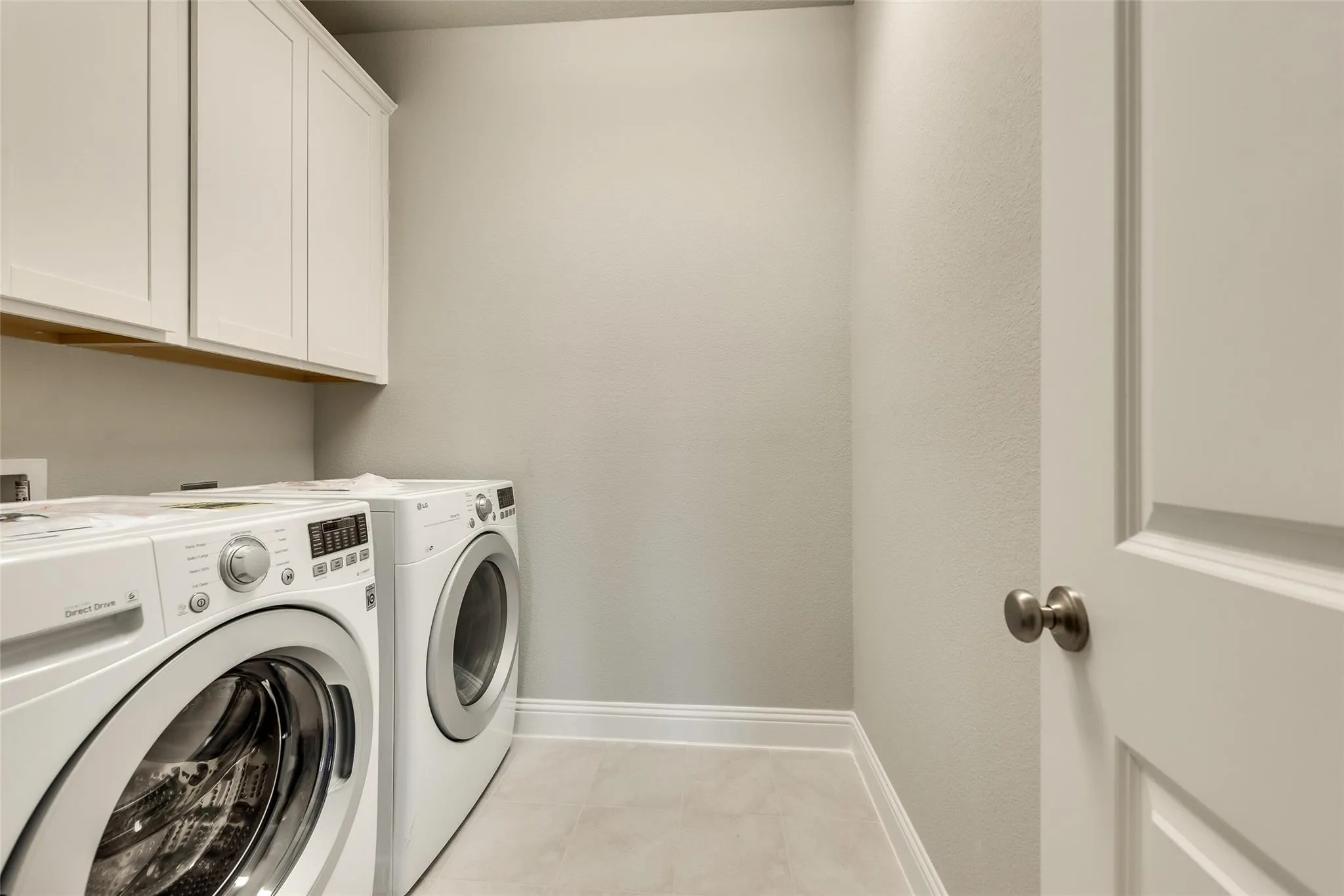 White upper cabinetry, light-toned walls, and neutral flooring