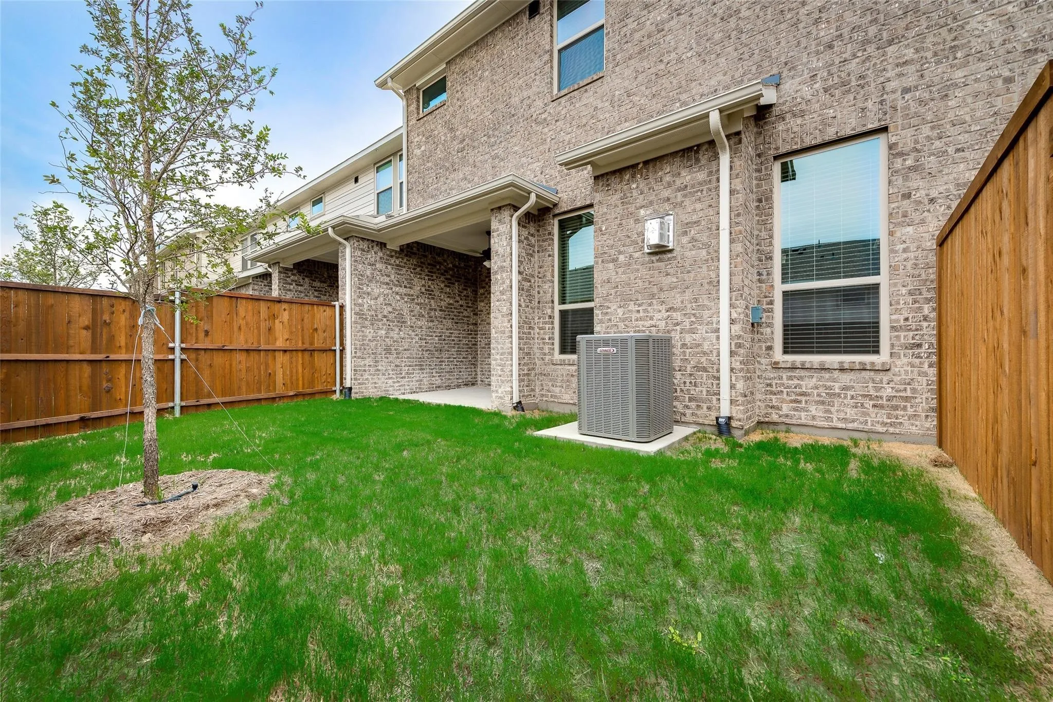 Private outdoor space with a grass lawn, privacy fencing, and a covered patio