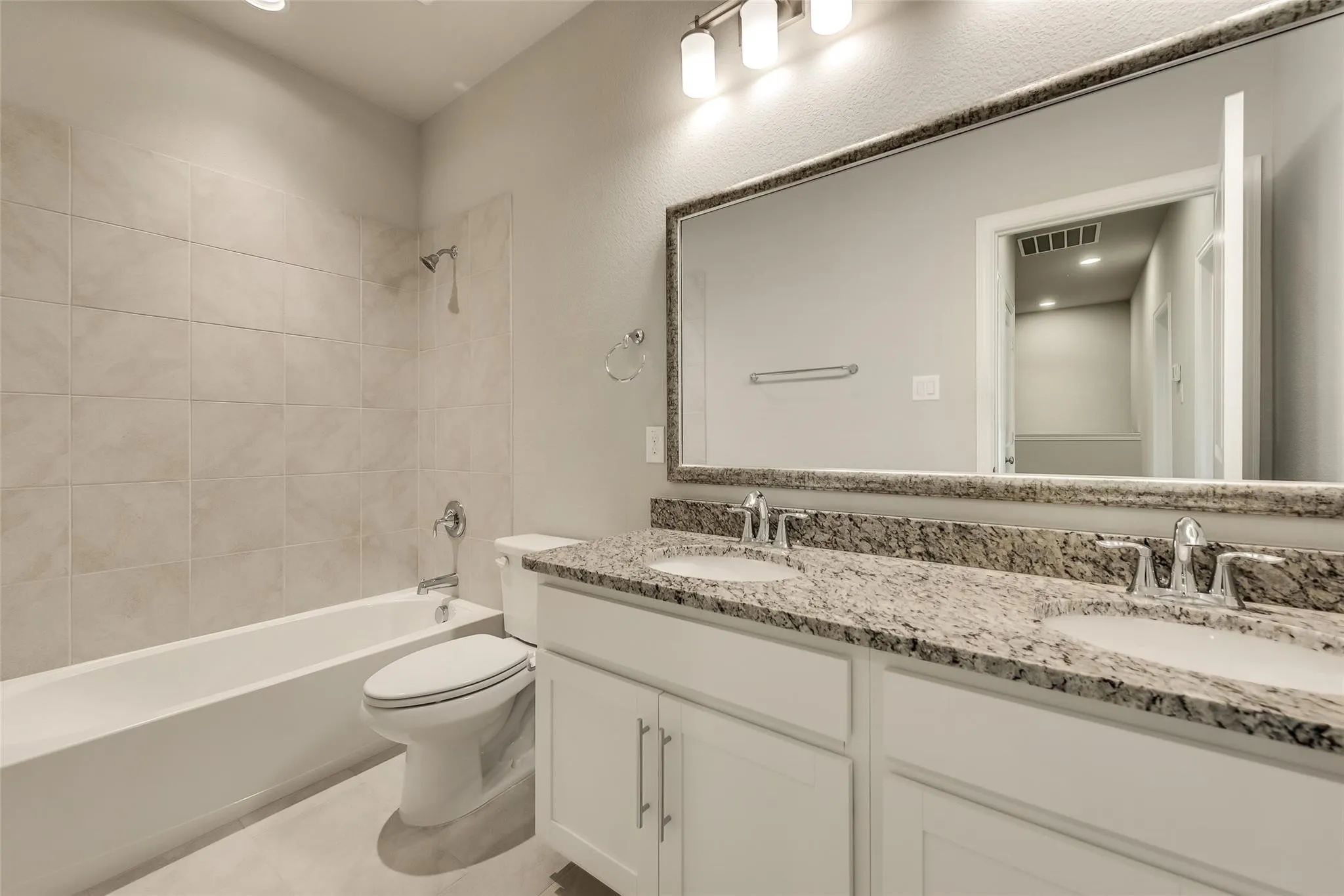Double vanity with granite countertop, undermount sinks, and chrome fixtures