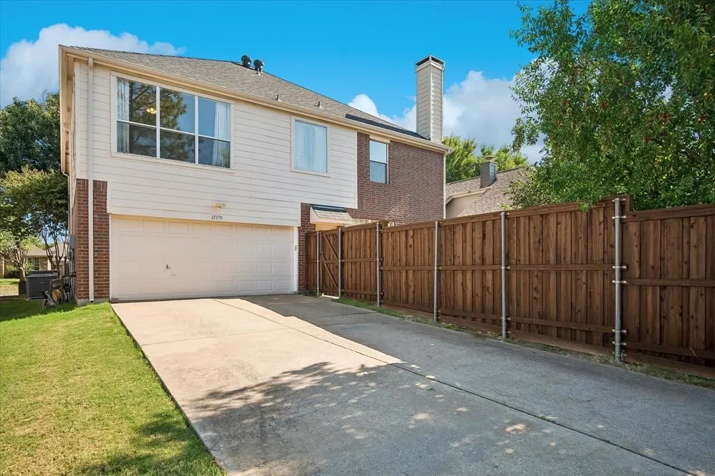 Two-story exterior with brick and siding facade, an attached garage, and a concrete driveway
