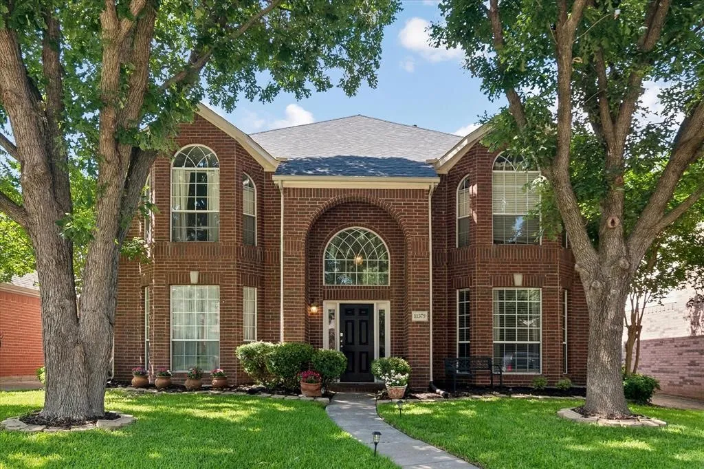 Brick exterior residence featuring a gabled roofline and arched windows