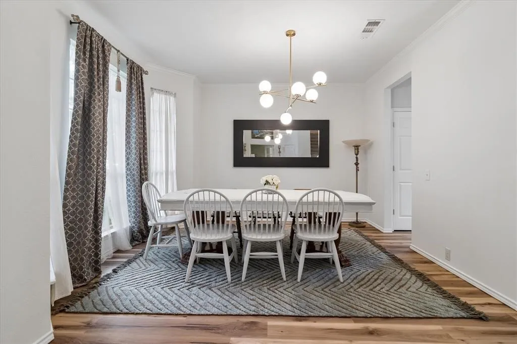 Wood-finish flooring, white walls, and a contemporary chandelier