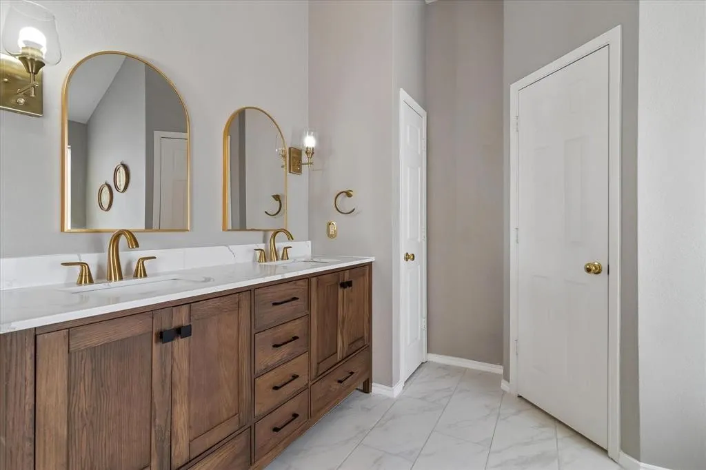 Dual vanity with a white countertop and brass-finish fixtures