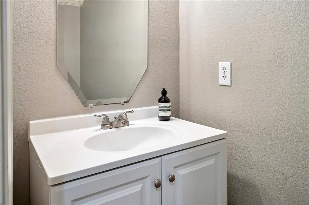 White vanity with cabinet storage, integrated sink, and brushed nickel faucet