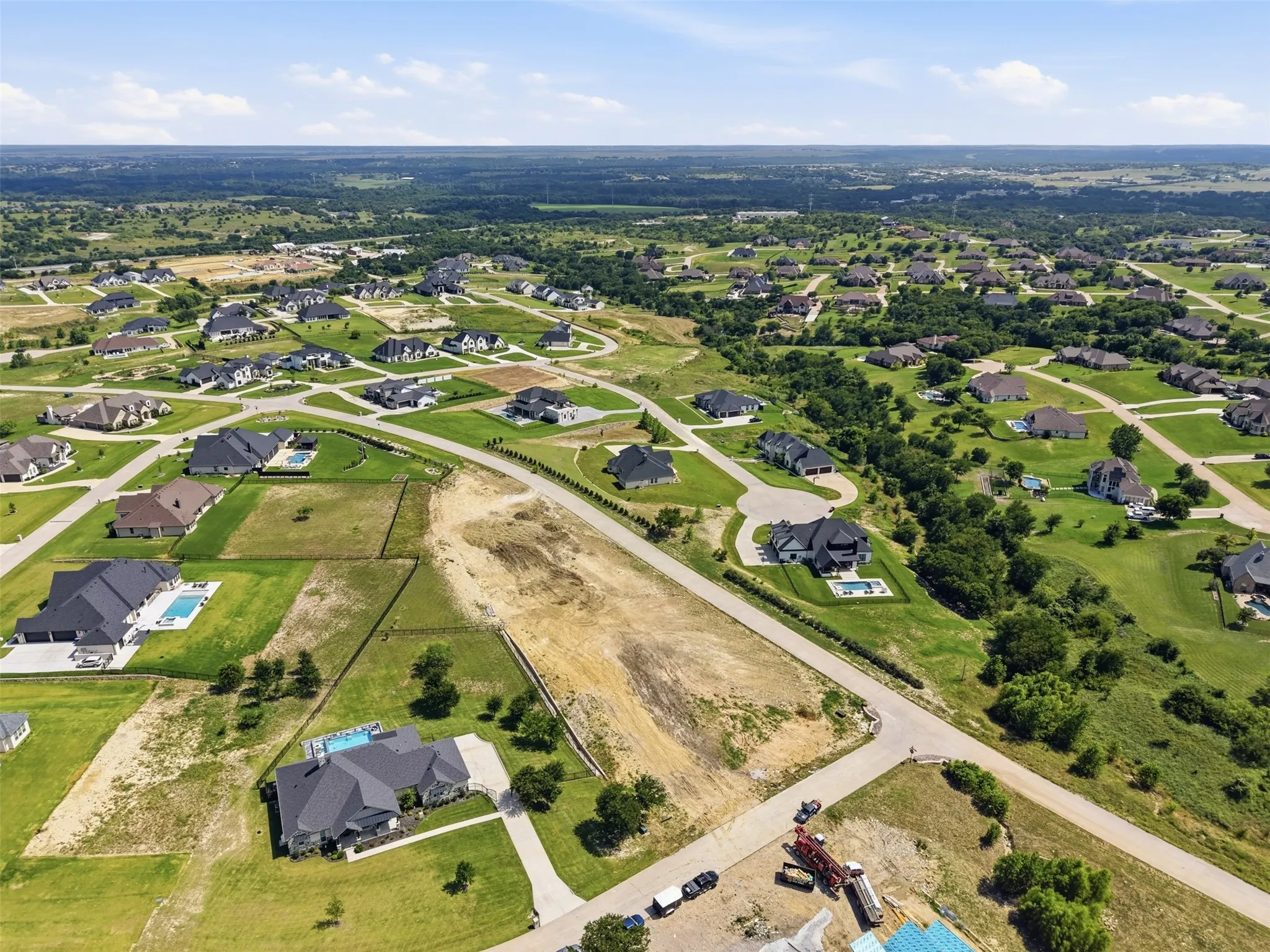 Expansive land parcel within a residential development, surrounded by custom residences