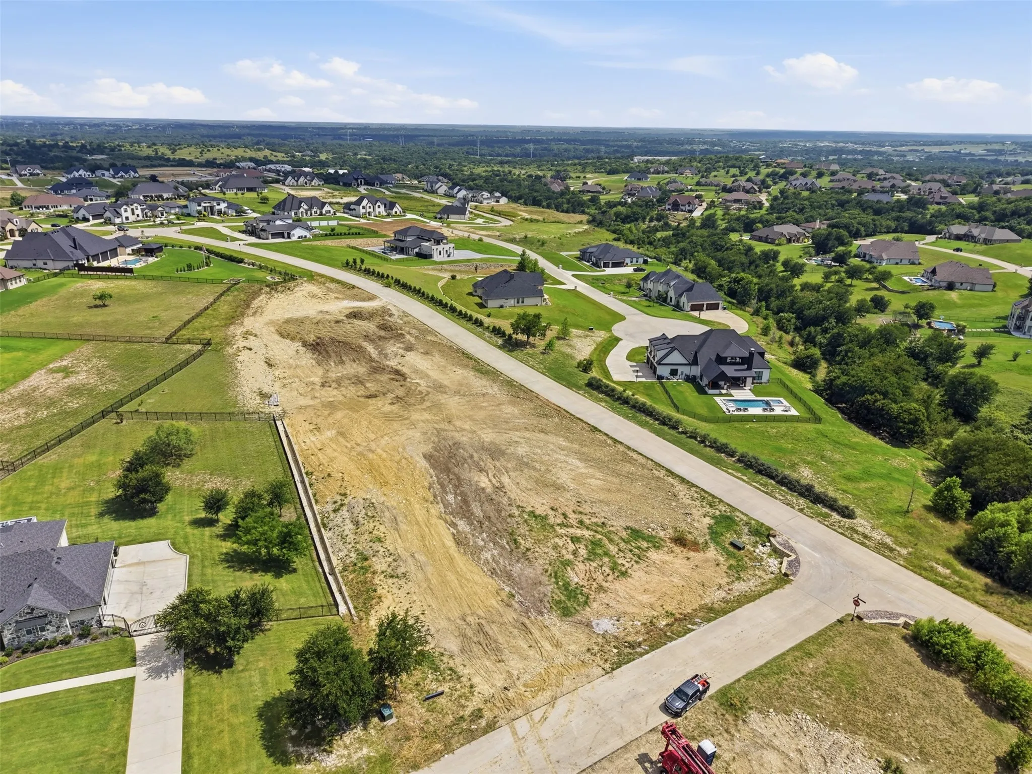Expansive undeveloped parcel located on a paved road, surrounded by established residential properties