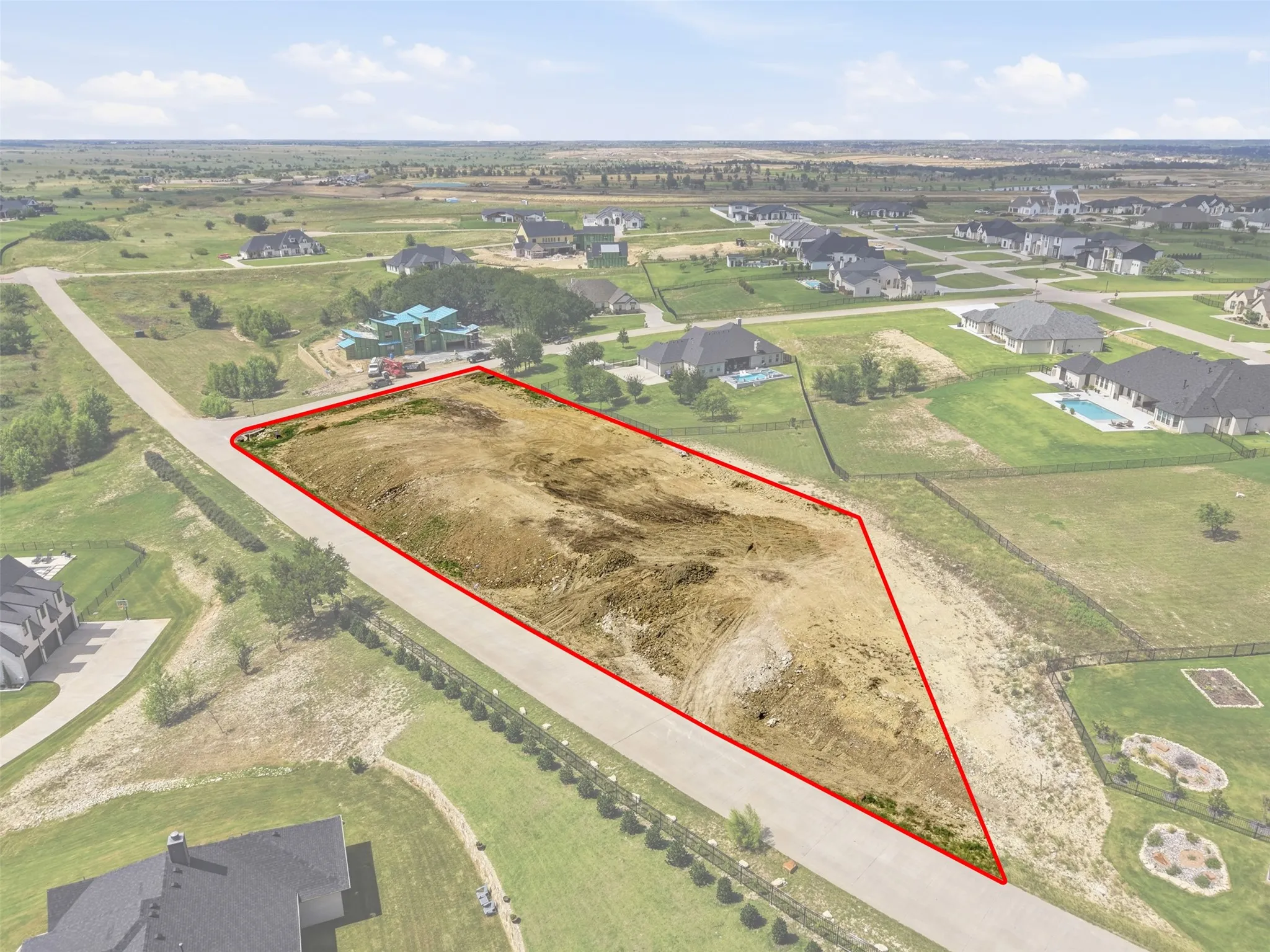 Expansive land lot with clear boundaries, bordered by a paved road