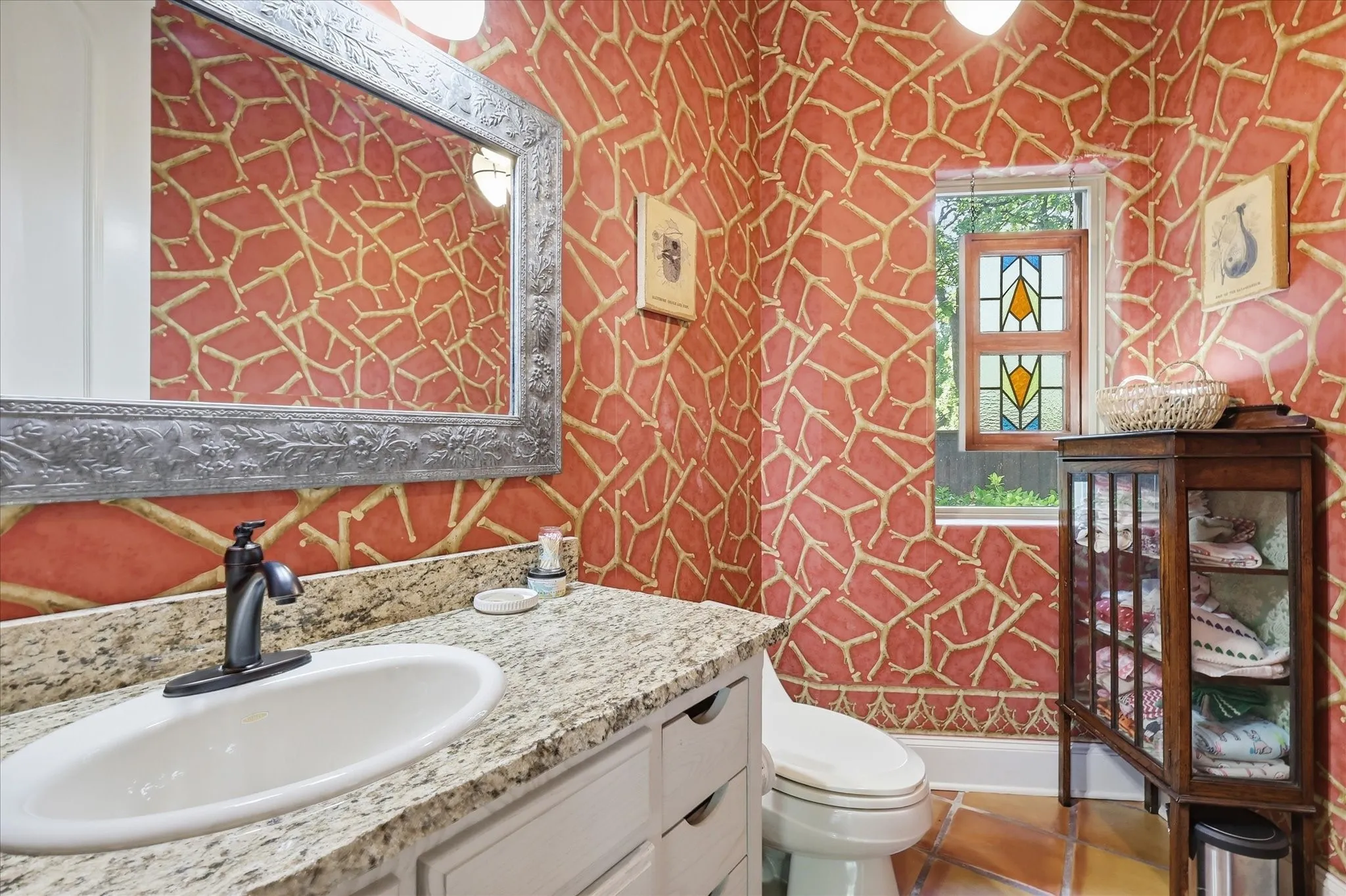 Vanity with light-toned countertop, oval undermount sink, and matte black faucet