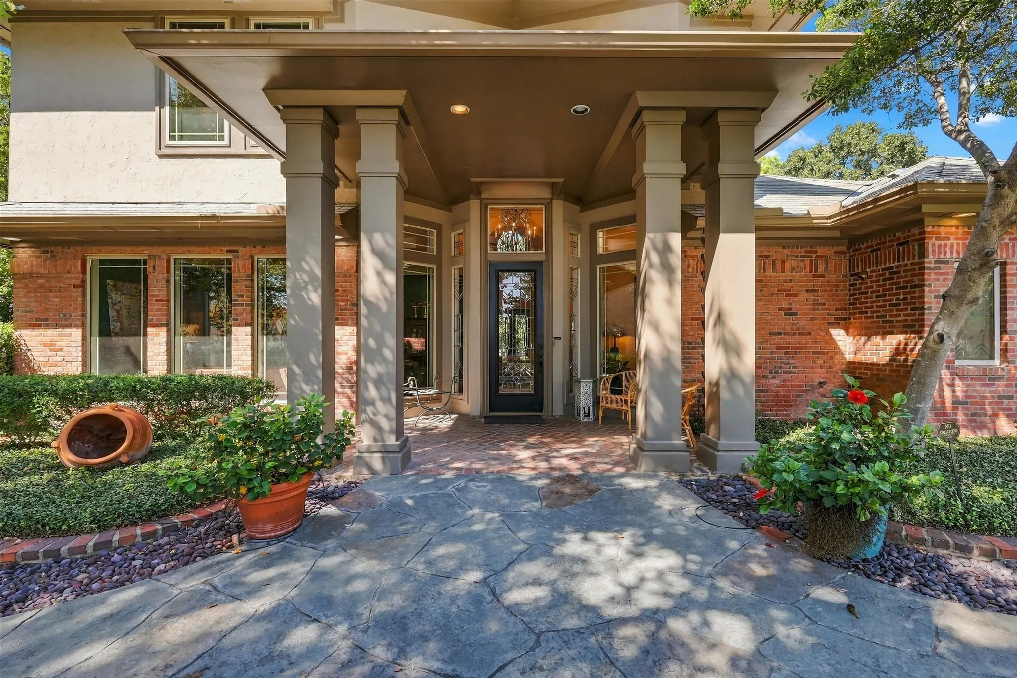 Stucco and brick exterior with a prominent covered entry featuring square columns