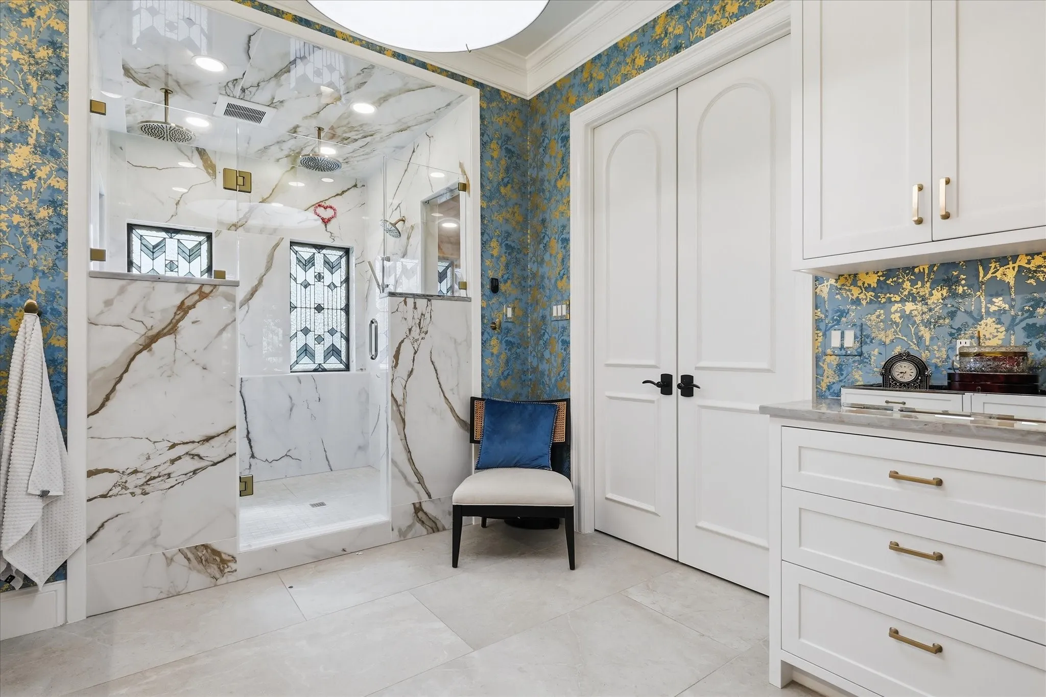 Expansive walk-in shower with dual rain shower heads and marble-look wall tiling