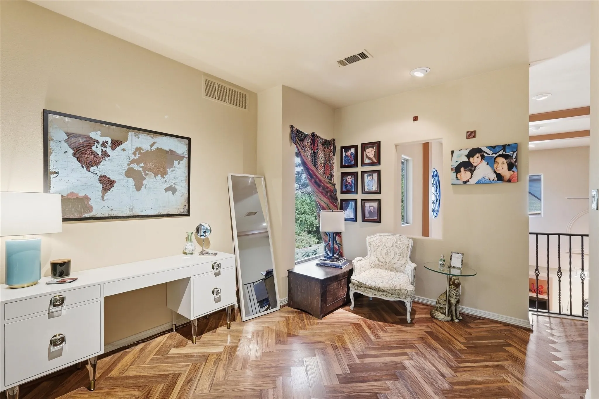 Herringbone wood-finish flooring, recessed lighting, and a white interior door with decorative glass inlay