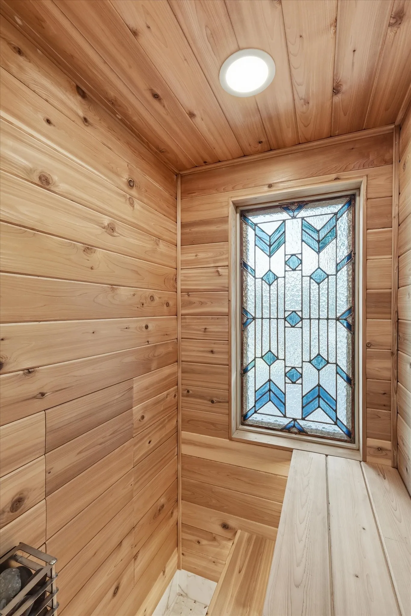 Wood paneling throughout, built-in wooden bench, built-in wooden stairs, recessed lighting, and a stained glass window