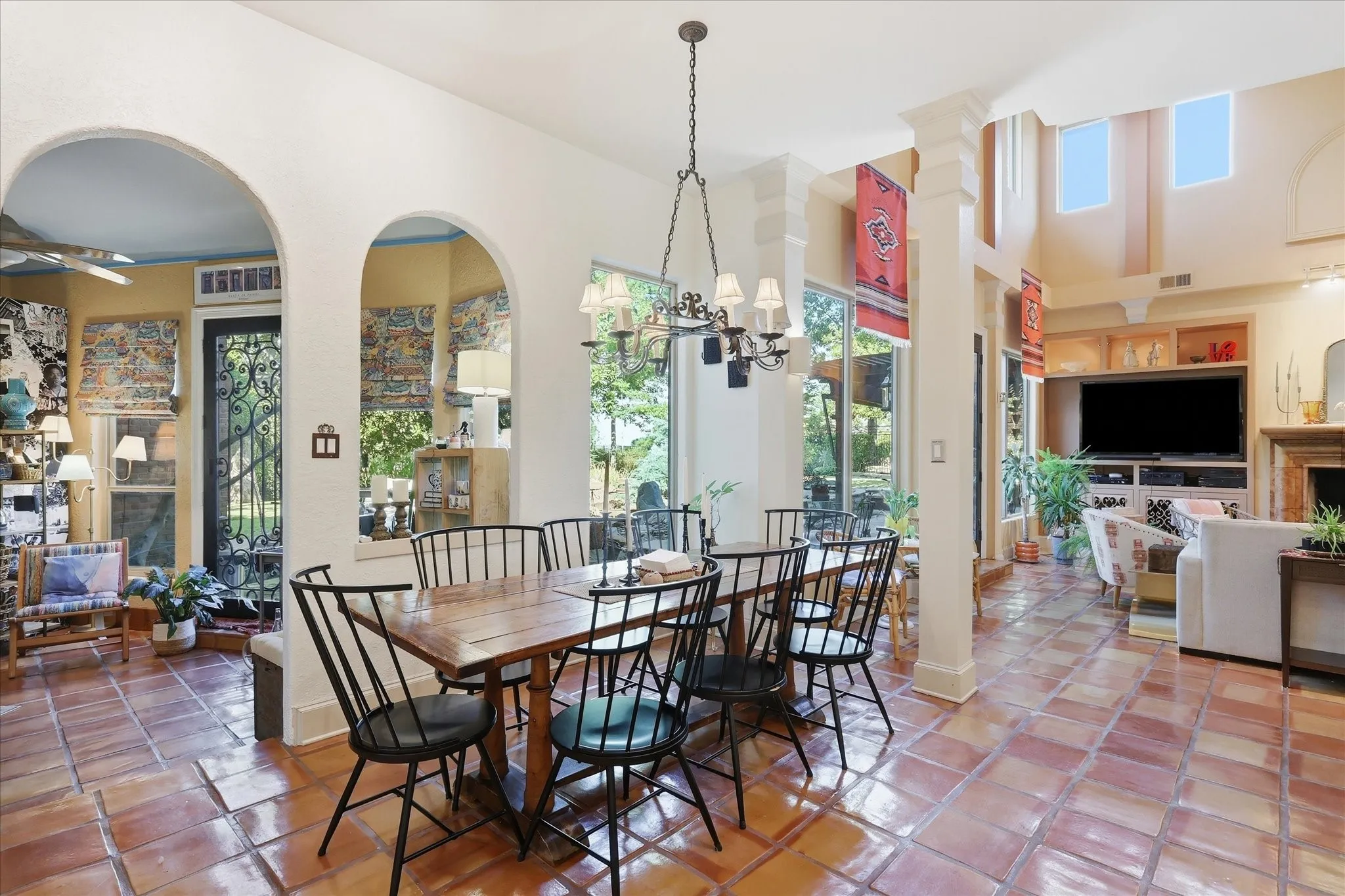 Spacious interior featuring terracotta tile flooring, archways, and a chandelier