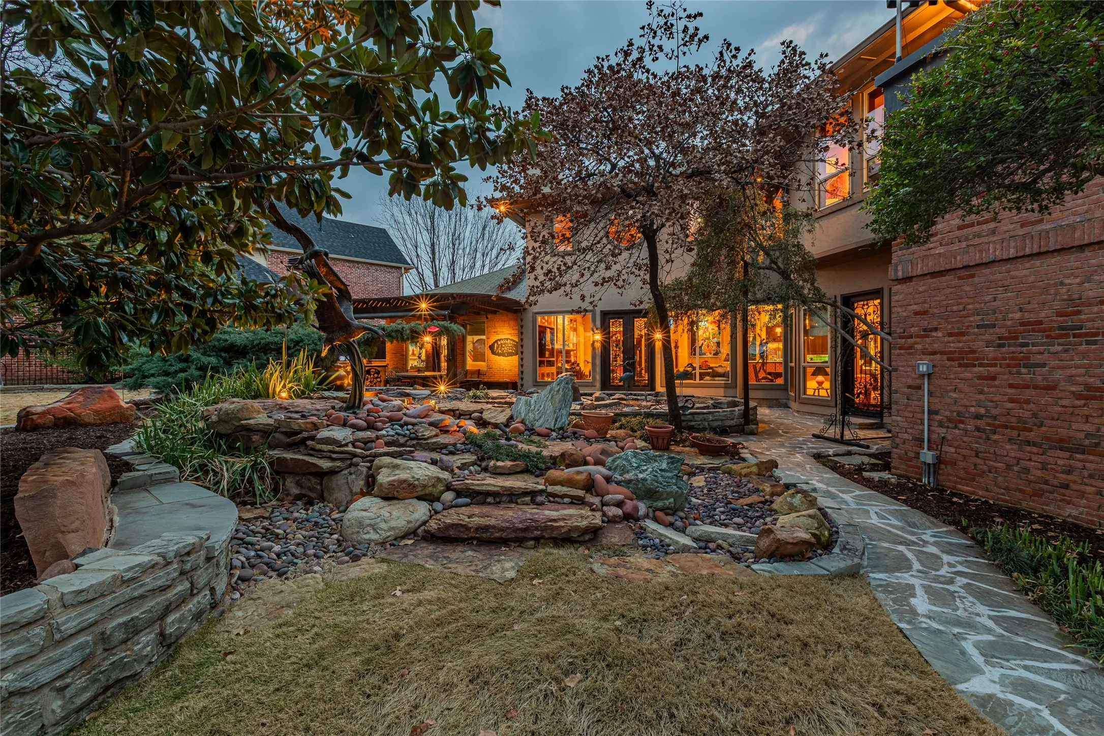 Stone paver walkway leading to an extensive rock garden with integrated lighting