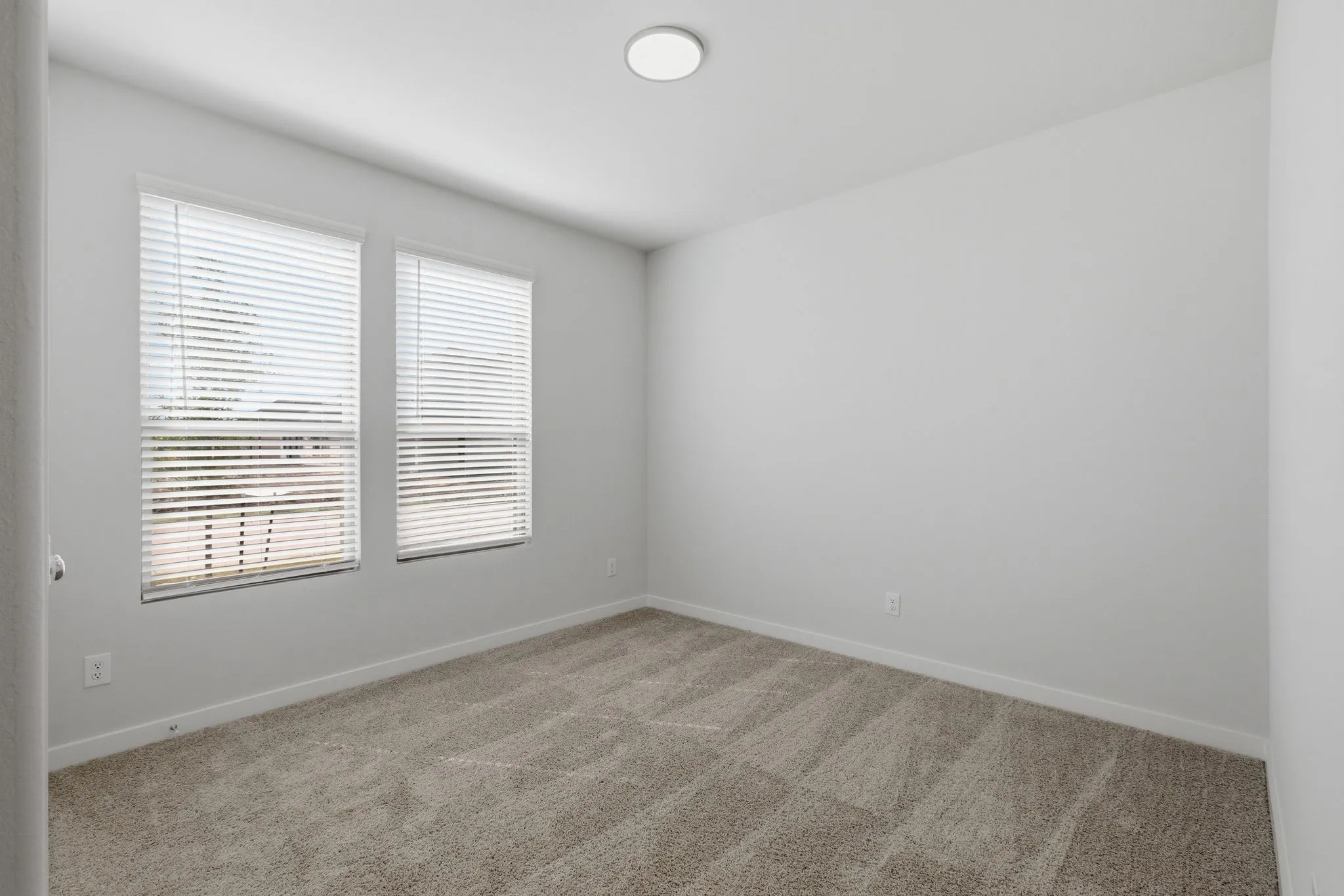 Recessed ceiling light fixture and two windows with blinds