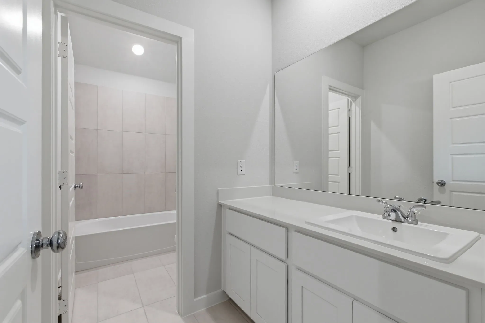 White vanity with a single basin, chrome faucet, and integrated countertop