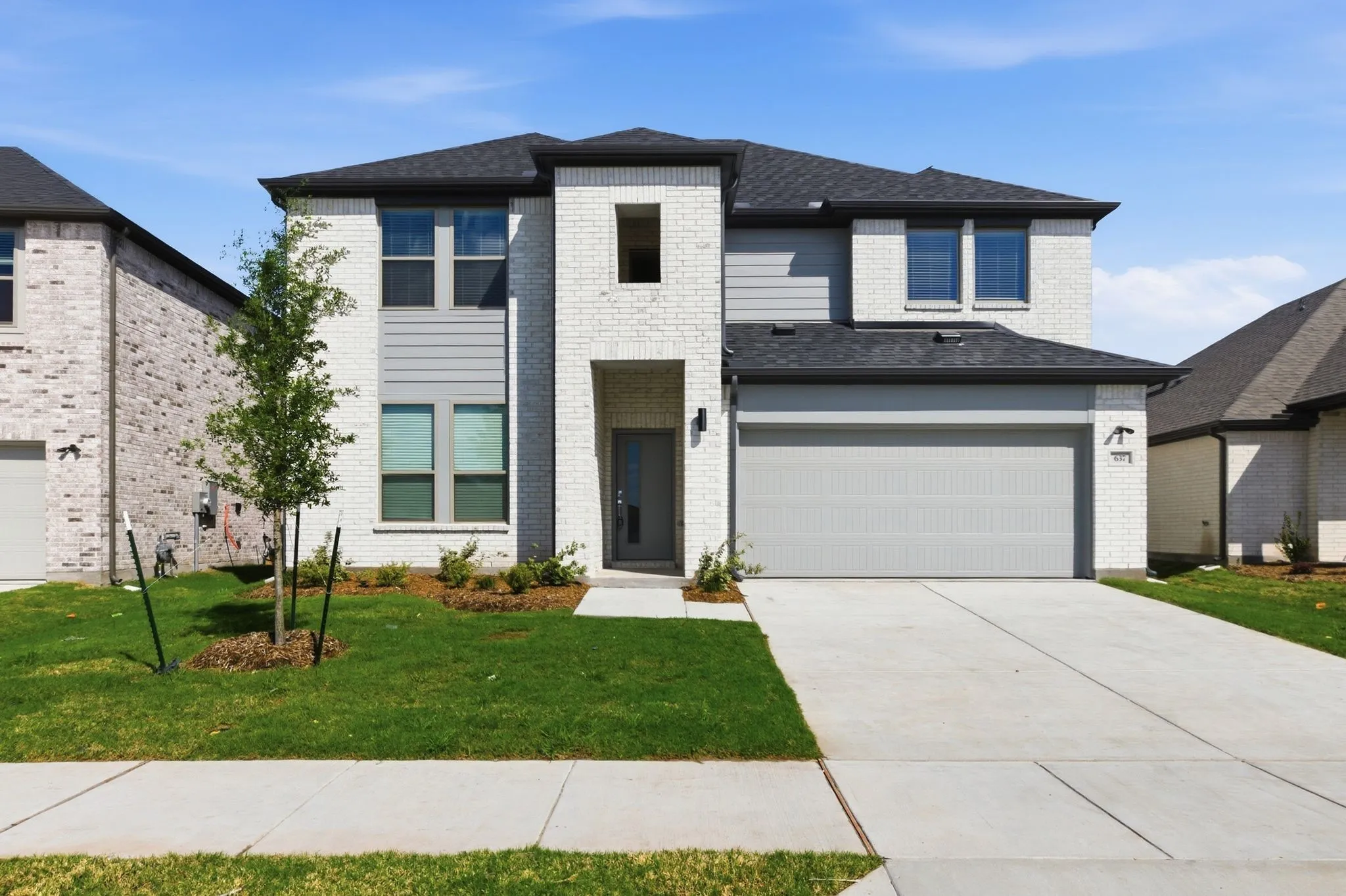 Two-story exterior with white brick and gray siding accents