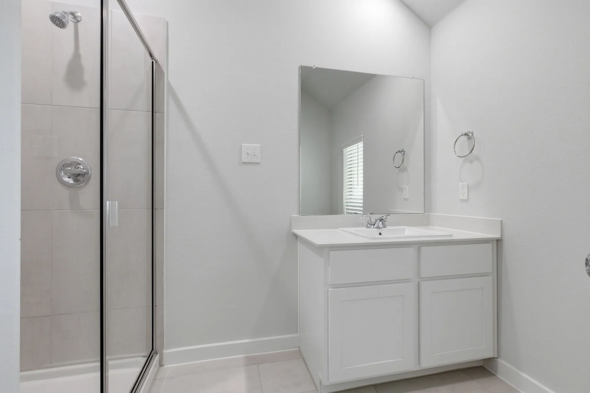White vanity with a single basin sink, chrome faucet, and rectangular mirror