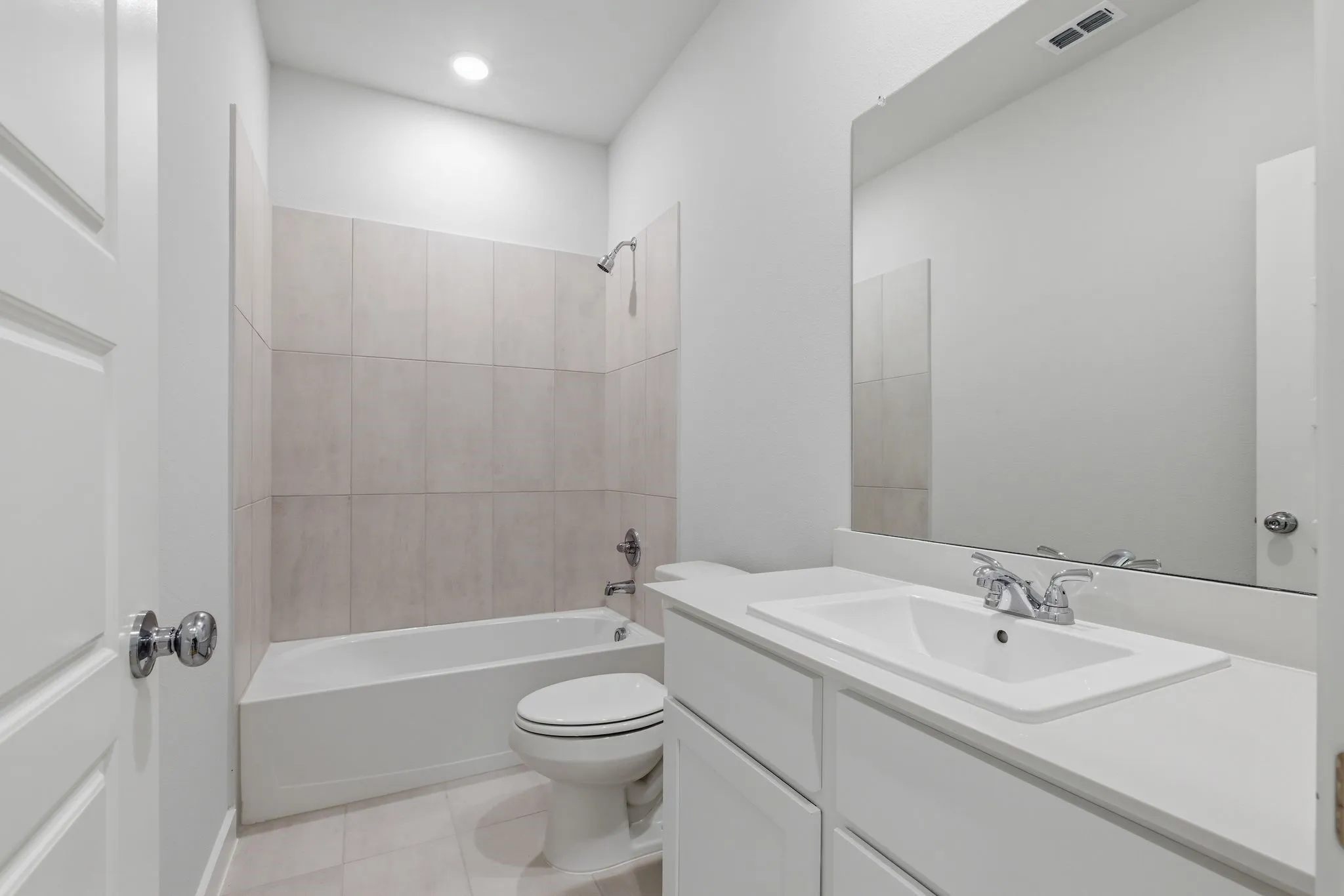 White vanity with a rectangular undermount sink, a chrome faucet, and a large mirror